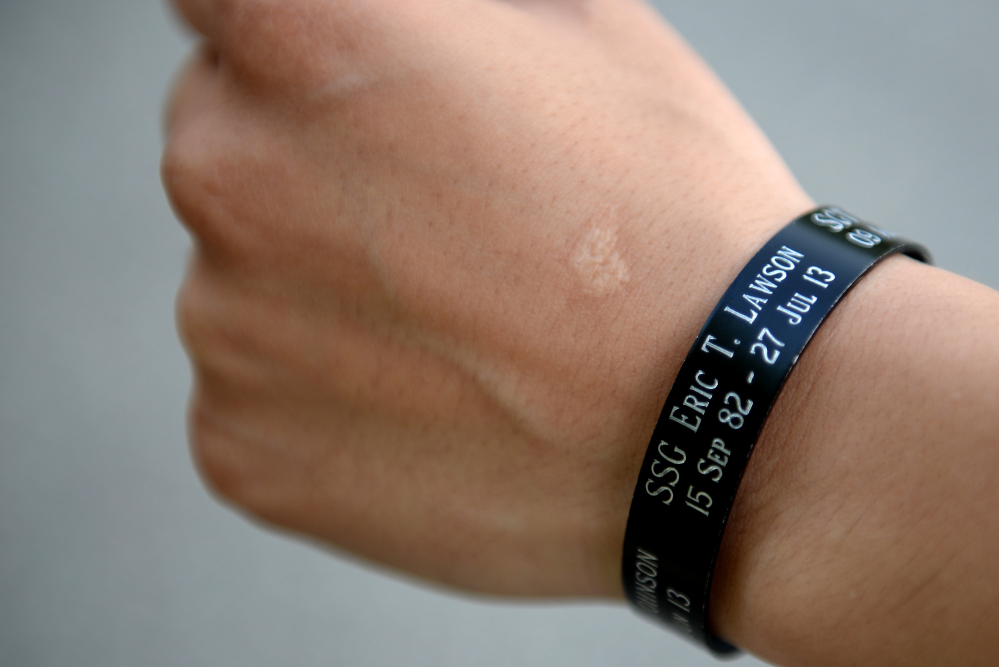U.S. Army Sgt. Melissa Raposo, 2nd Platoon, 359th Inland Cargo Transfer Company, 10th Transportation Battalion, 7th Transportation Brigade (Expeditionary) squad leader, wears a memorial bracelet at Fort Eustis, Va., July 25, 2014. Soldiers from the 359th ICTC ran a memorial 5K in honor of three comrades who lost their lives nearly a year ago while deployed to Bagram Air Base, Afghanistan. (U.S. Air Force photo by Senior Airman Teresa J.C. Aber/Released)
