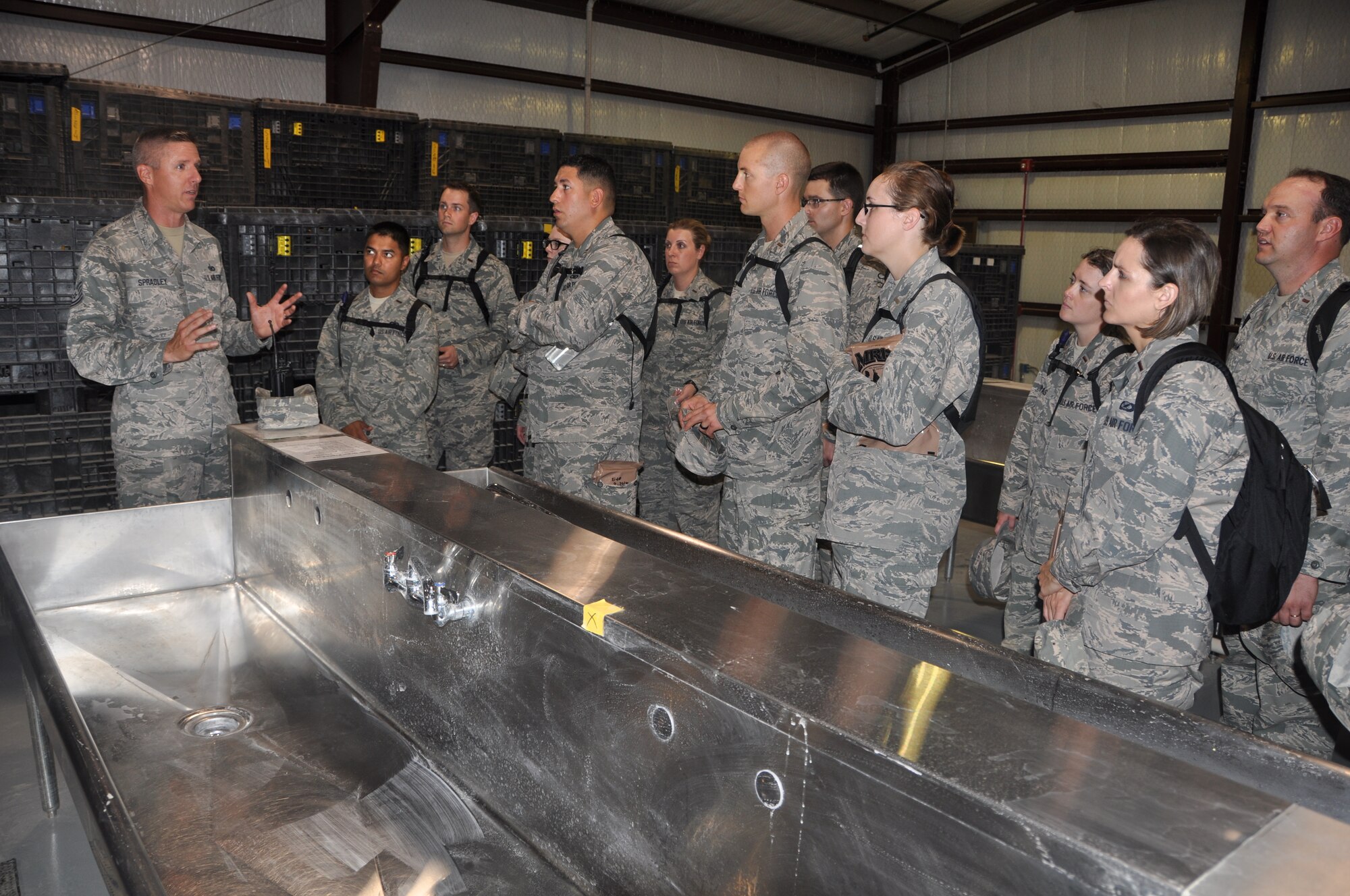 Tech. Sgt. Christopher Spradley, Military Training Instructor, 319th Training Squadron, Joint Base San Antonio-Lackland, Texas explains the gas mask donning process to Air Force chaplain candidates in the Chaplain Candidate Program during their visit to the Basic Expeditionary Airman Skills Training (BEAST) Course, 24 July 2014. (U.S. Air Force photo by Capt. Cris Medina)
