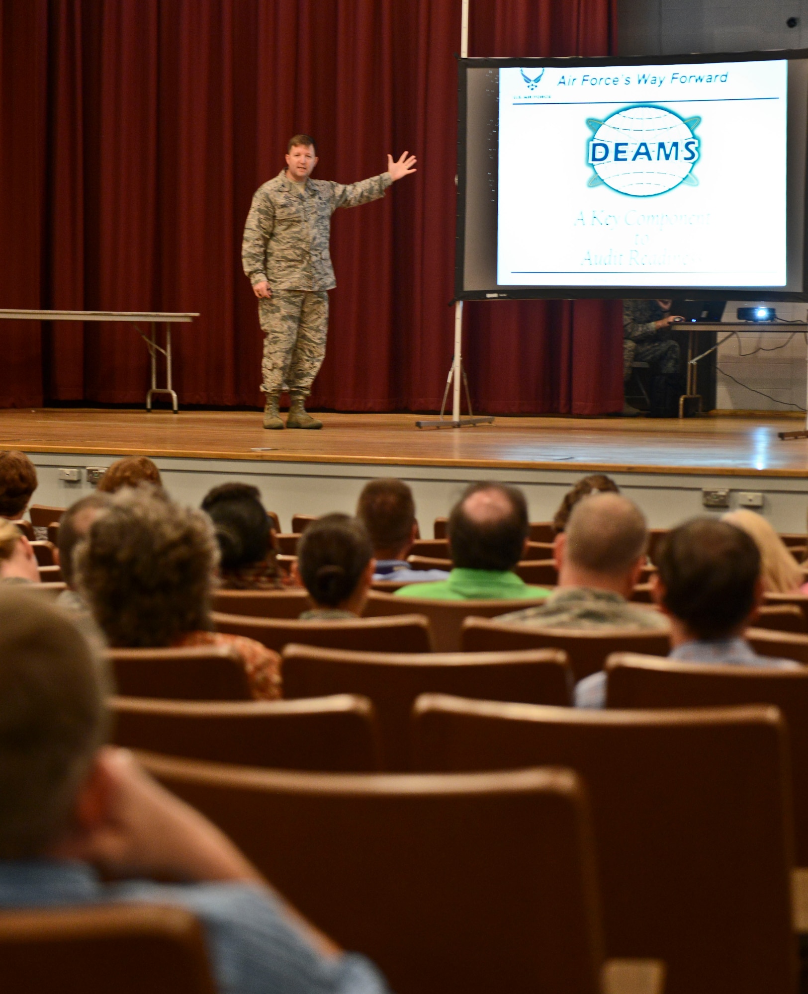 U.S. Air Force Col. Timothy Dunster, Air Combat Control/Financial Management, chief of the financial operations division, speaks during a finance meeting held at the old base theater, Shaw Air Force Base, S.C., July 22, 2014.  The event was held to highlight adjustments for the fiscal year 2015 transition to the new financial program, DEAMS. (U.S. Air Force photo by Senior Airman Tabatha Zarrella/Released)