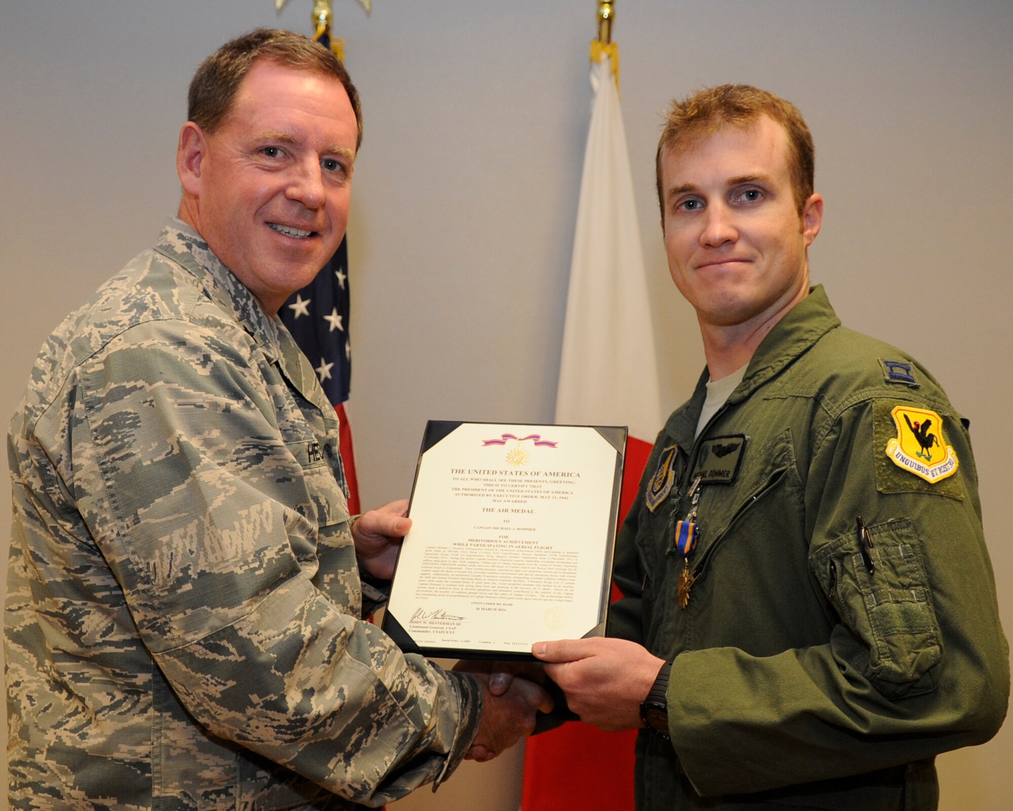 U.S. Air Force Brig. Gen. James Hecker, 18th Wing commander, presents Capt. Michael Dommer, 33rd Rescue Squadron chief of safety, with the Air Medal on Kadena Air Base, Japan, July 28, 2014. This medal was given for participating in sustained aerial flight during Operation Enduring Freedom while under the constant threat of small arms fire and rocket propelled grenades. (Photo by Senior Airman Marcus Morris/Released)