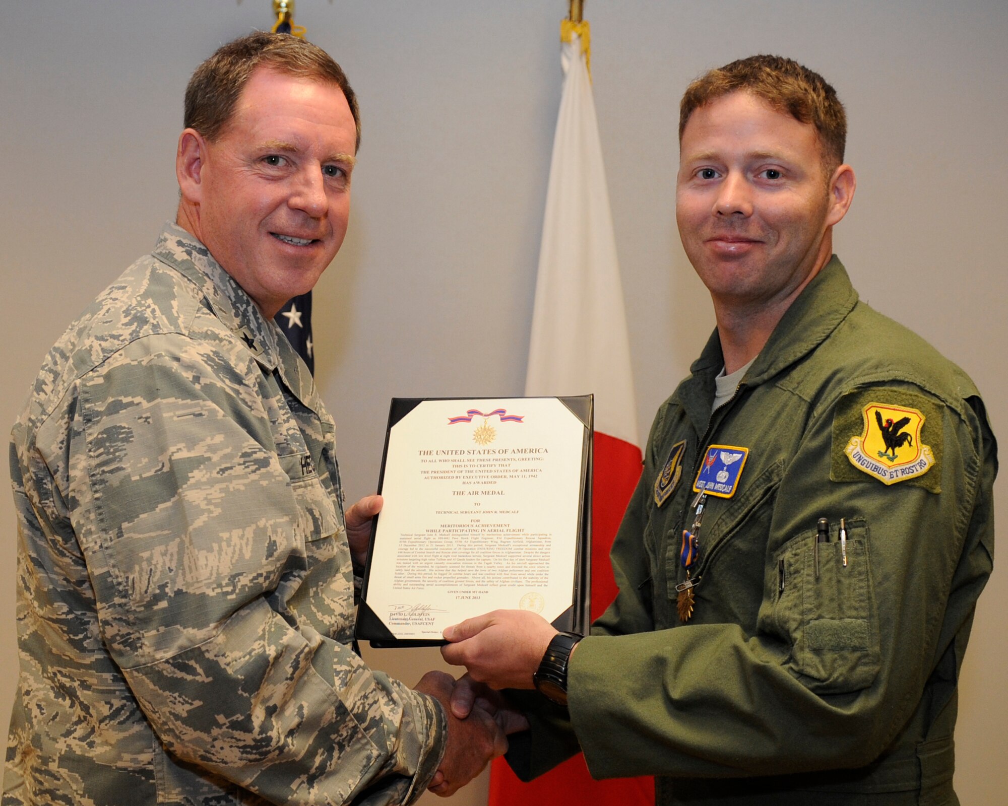 U.S. Air Force Brig. Gen. James Hecker, 18th Wing commander, presents Tech. Sgt. John Medcalf, 33rd Rescue Squadron staff superintendant, with the Air Medal on Kadena Air Base, Japan, July 28, 2014. This medal was given for participating in sustained aerial flight leading to 20 executed Operation Enduring Freedom combat missions. (Photo by Senior Airman Marcus Morris/Released)