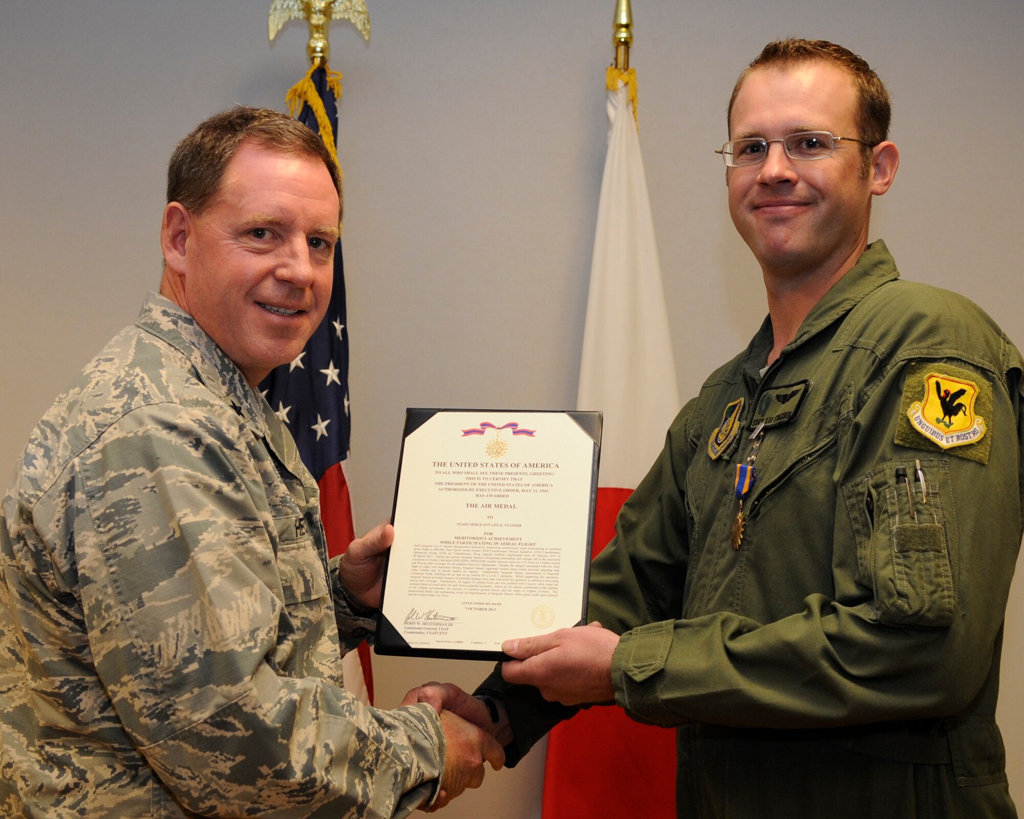U.S. Air Force Brig. Gen. James Hecker, 18th Wing commander, presents Staff Sgt. Lee Stasser, 33rd Rescue Squadron mobility noncommissioned officer, with the Air Medal on Kadena Air Base, Japan, July 28, 2014. This medal was given for participating in sustained aerial flight during Operation Enduring Freedom and over 421 hours of combat search and rescue operations. (Photo by Senior Airman Marcus Morris/Released)