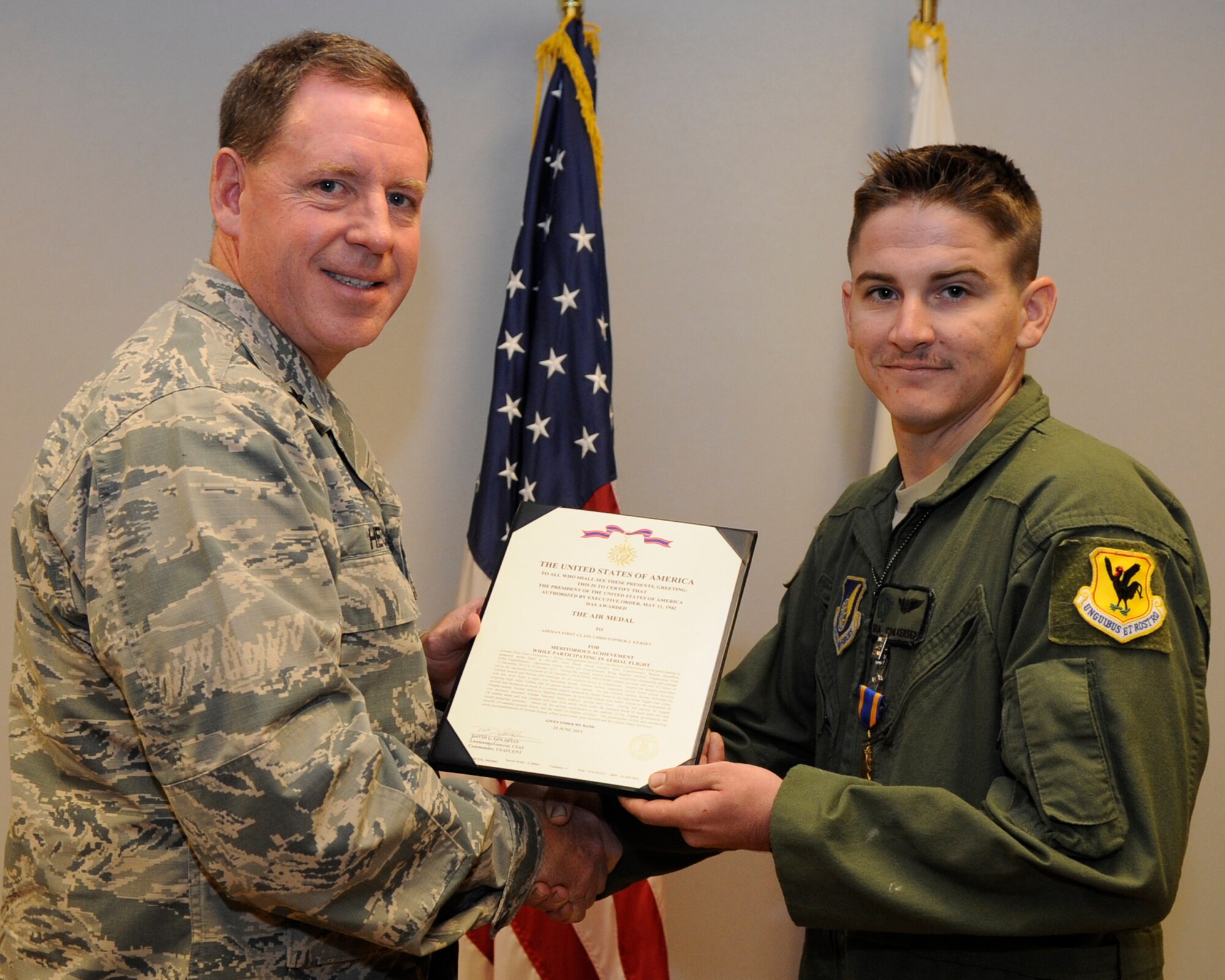 U.S. Air Force Brig. Gen. James Hecker, 18th Wing commander, presents Senior Airman Christopher Kersey, 33rd Rescue Squadron mobility airman, with the Air Medal on Kadena Air Base, Japan, July 28, 2014. This medal was given for participating in sustained aerial flight during Operation Enduring Freedom and over 421 hours of combat search and rescue operations. (Photo by Senior Airman Marcus Morris/Released)