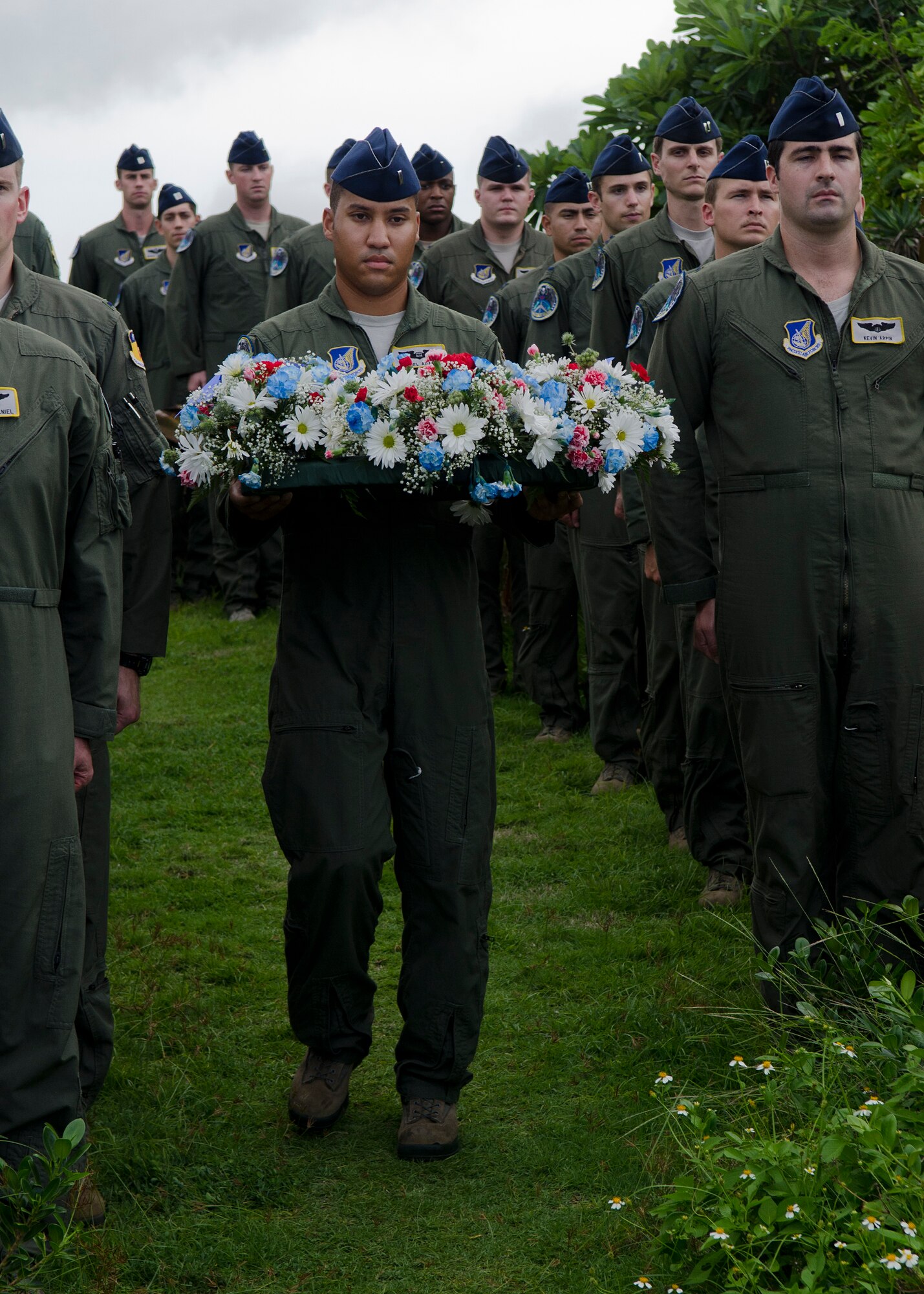 First Lt. Daniel Adams carries a wreath during the annual Raider 21 memorial ceremony July 21, 2014, in Adelup, Guam. Members of Team Andersen joined together with Government of Guam representatives to remember the six Airmen who lost their lives when a B-52 Stratofortress that had the Raider 21 call sign crashed off the coast of Guam July 21, 2008.  (U.S. Air Force photo by Senior Airman Katrina M. Brisbin/Released) 