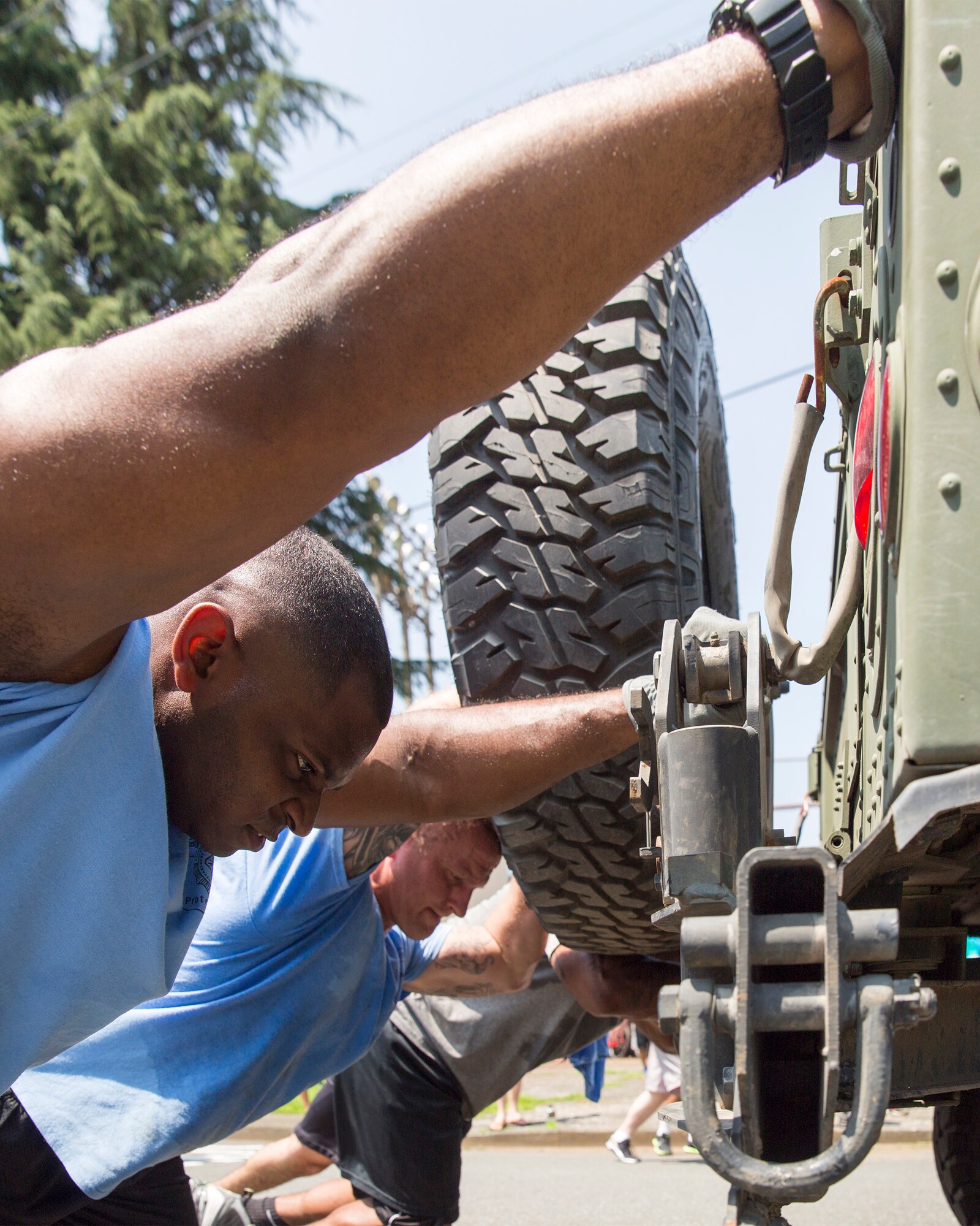 Airmen with the 374th Security Forces Squadron push a Humvee during Airman Appreciation Day at Yokota Air Base, Japan, July 25, 2014. Sports representatives from various units around Yokota organized teams to complete in sports such as flag football, sumo, volleyball, and soccer.  (U.S. Air Force photo by Osakabe Yasuo/Released)