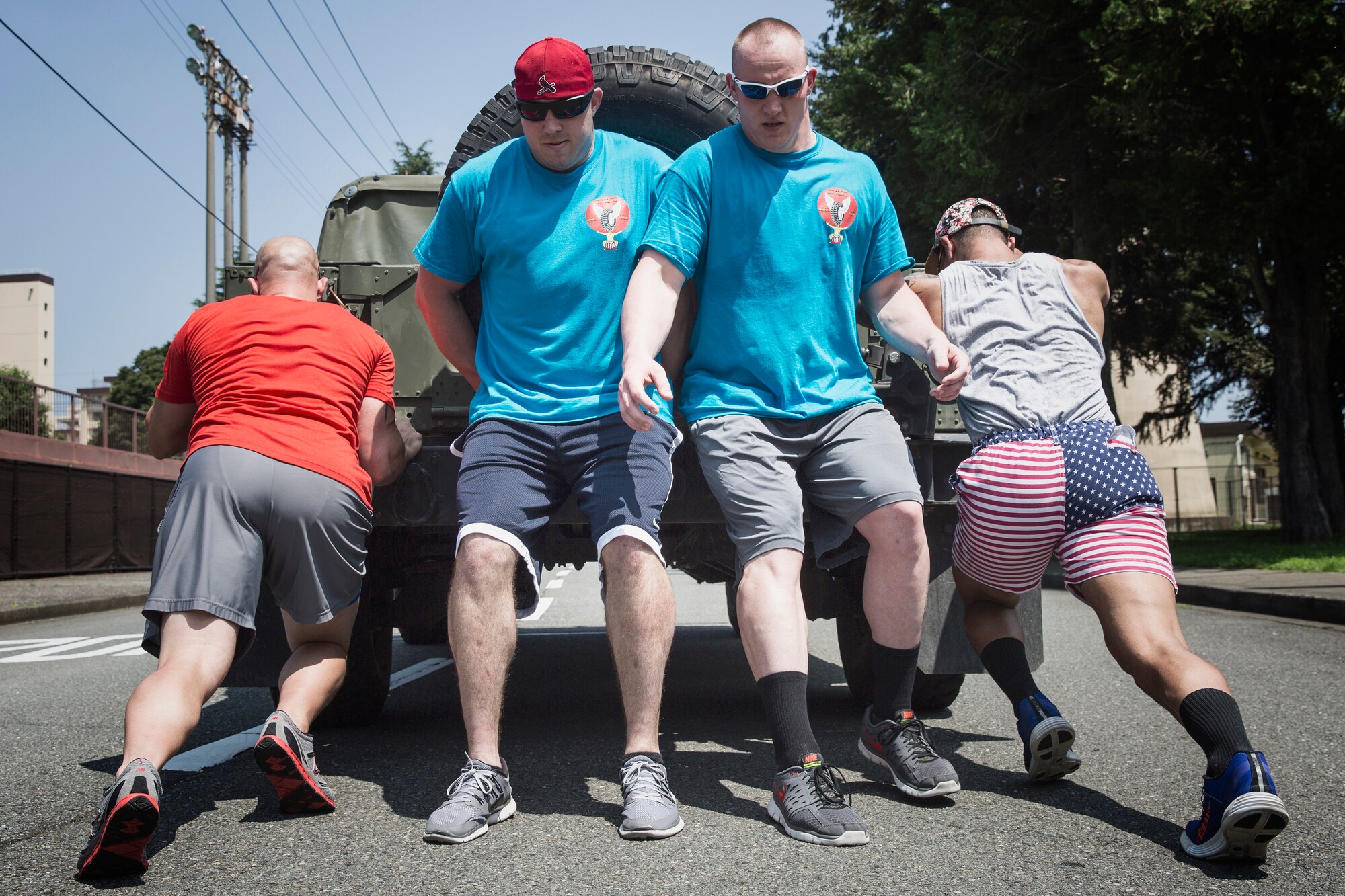 Airmen with the 374th Logistics Readiness Squadron push a Humvee during Airman Appreciation Day at Yokota Air Base, Japan, July 25, 2014. This is the third annual Airmen Appreciation Day. (U.S. Air Force photo by Osakabe Yasuo/Released)