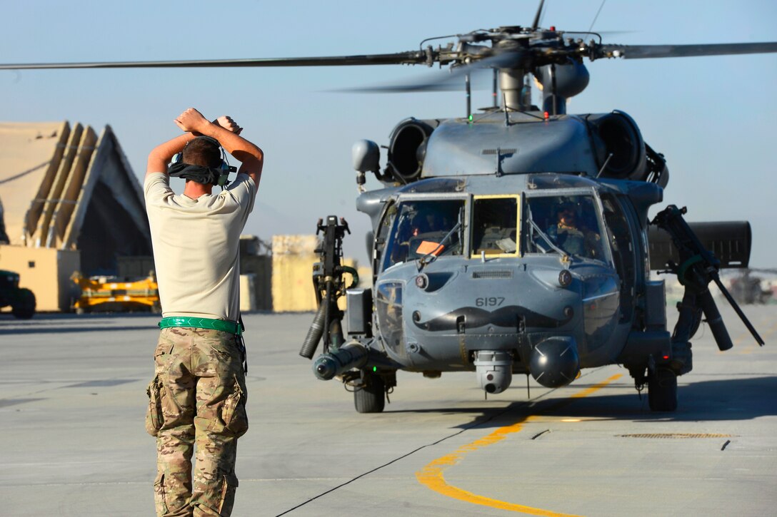 U.S. Air Force Senior Airman Trevor Eastlick marshals in a HH-60G Pave Hawk helicopter after conducting mission rehearsals on Bagram Airfield, Afghanistan, July 19, 2014. Eastlick, a crew chief, is assigned to the 455th Expeditionary Aircraft Maintenance Squadron.