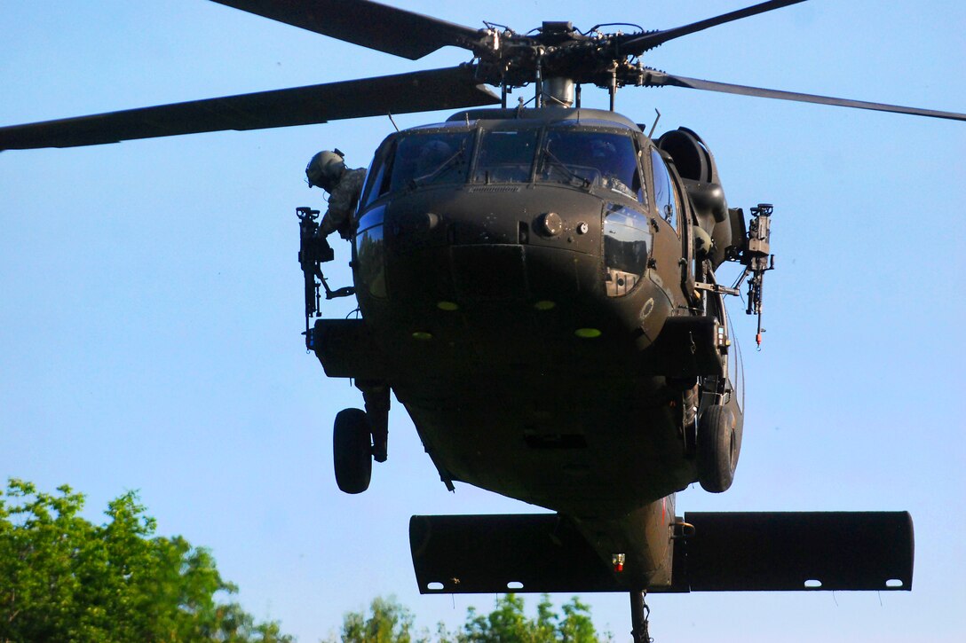 Army Spc. Brandon Harris stows his M-240H machine gun while his UH-60 Black Hawk helicopter makes its approach into the forward arming and refueling point on Camp Buckner, N.Y., July 21, 2014. Harris, a crew chief, is assigned to Company B, 2nd Assault Helicopter Battalion, 10th Combat Aviation Brigade. The soldiers provided air support to cadets from the U.S. Military Academy in West Point, N.Y., during their summer cadet field training.