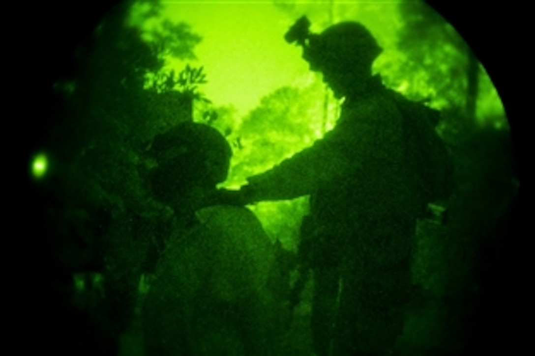 As seen through a night-vision device, a Marine controls a simulated detainee during a raid exercise on Camp Lejeune, N.C., July 27, 2014. The unit is conducting realistic urban training to prepare for deployment at the end of the year. The Marine is assigned to Lima Company, Battalion Landing Team 3rd Battalion, 6th Marine Regiment, 24th Marine Expeditionary Unit.