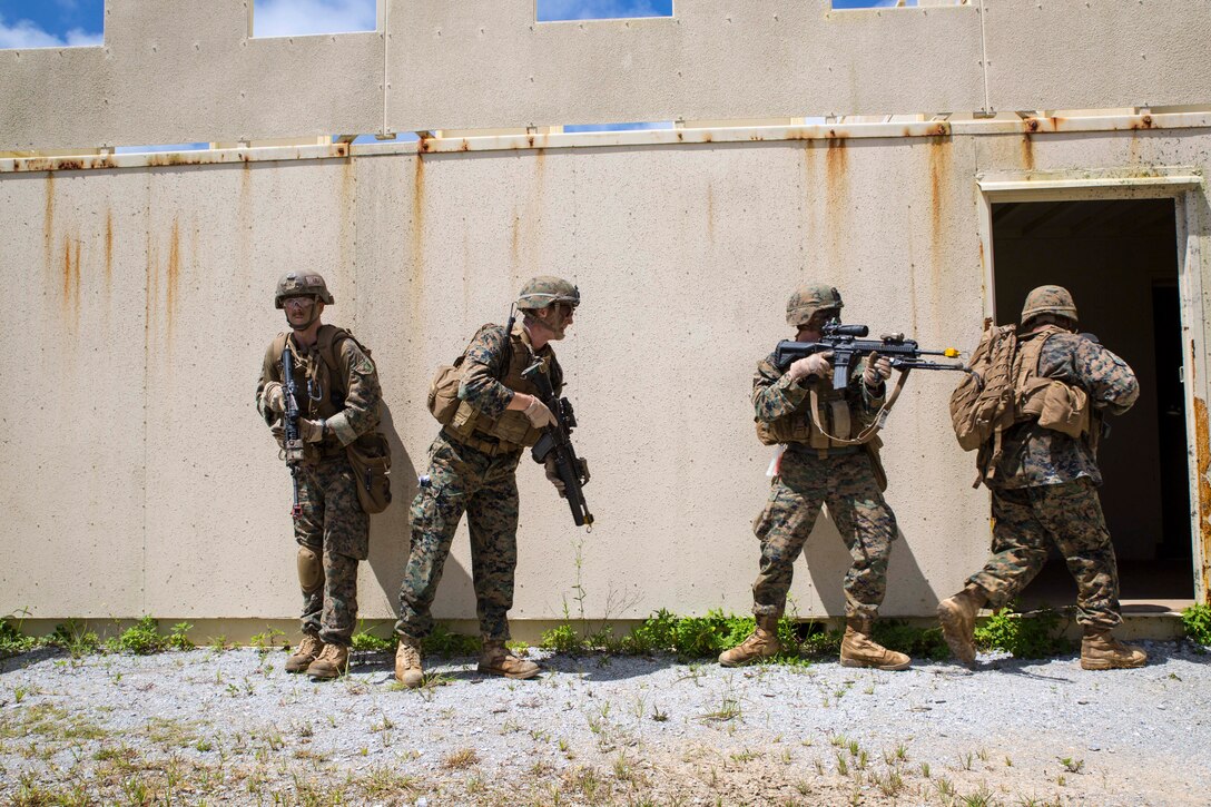 Marines prepare to clear a building July 18 at the Central Training Area, Okinawa, Japan, during a Marine Expeditionary Unit exercise. The training scenario called for the 31st MEU’s Battalion Landing Team to insert via aircraft into a landing zone near a simulated hostile village to seize and capture high-value individuals. The Marines are with 3rd Battalion, 5th Marine Regiment, 31st MEU. (U.S. Marine Corps photo by Cpl. Adam B. Miller/Released).