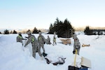 Alaska National Guard members clear a building roof in Cordova on Jan. 9, 2012. There are currently 57 National Guard members assisting citizens in this small Alaska town dig out from a series of winter storms.