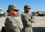 Army Sgt. Christina Christensen waits with another Soldier as their convoy escort team prepares to leave Camp Buehring, Kuwait, on Nov. 24, 2011, for Iraq.