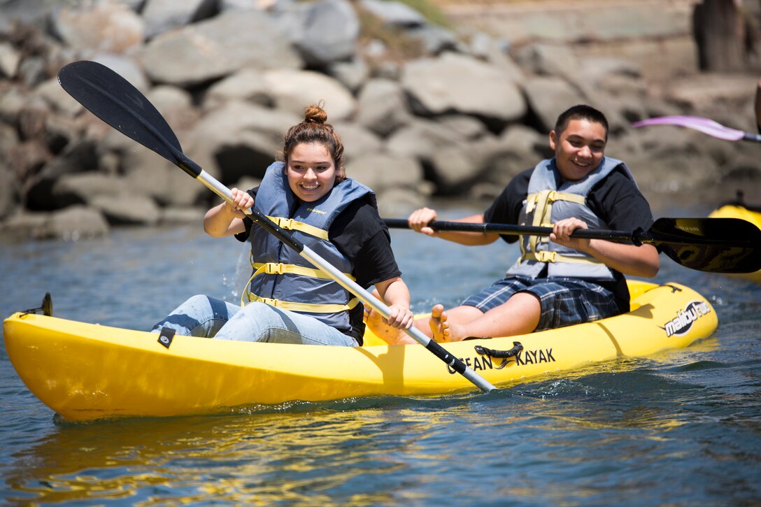 Teens particpating in the 12th Marine Corps District's first annual Teen Summit kayak in the bay aboard Marine Corps Recruit Depot San Diego, June 21, 2014.
