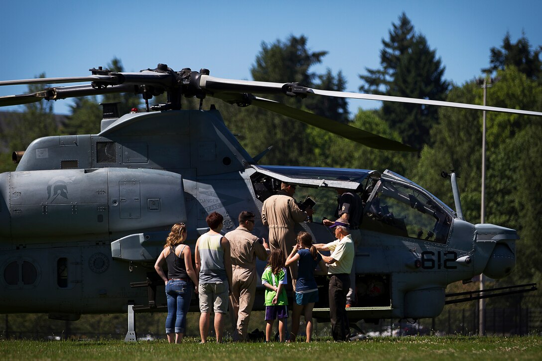 Maj. Daniel "Hungry" Hipol and Capt. Tony "Mimbo" LaVista, AH-1Z Super Cobra attack helicopter pilots with Marine Light Attack Training Squadron 303, answer questions from Seattle-area residents after landing their Super Cobra helicopter at the University of Washington during a Marine Week Seattle community relations event in Seattle, July 28, 2014. Marine Week, held in Seattle for the first time from July 26 - August 3, is the Marine Corps' largest annual celebration of country, community and Corps. Hipol, 39, is from West Palm Beach, Fla., and LaVista, 32, is from Los Gatos, Calif. (U.S. Marine Corps photo by Sgt. Reece Lodder)