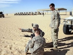 A Soldier in the Mankato, Minn., -based 2nd Battalion, 135th Infantry Regiment, reviews his kneeling firing position with two members of the Headquarters Company's sniper section on Jan. 5, 2012. Units in the battalion qualified with their individual weapons.