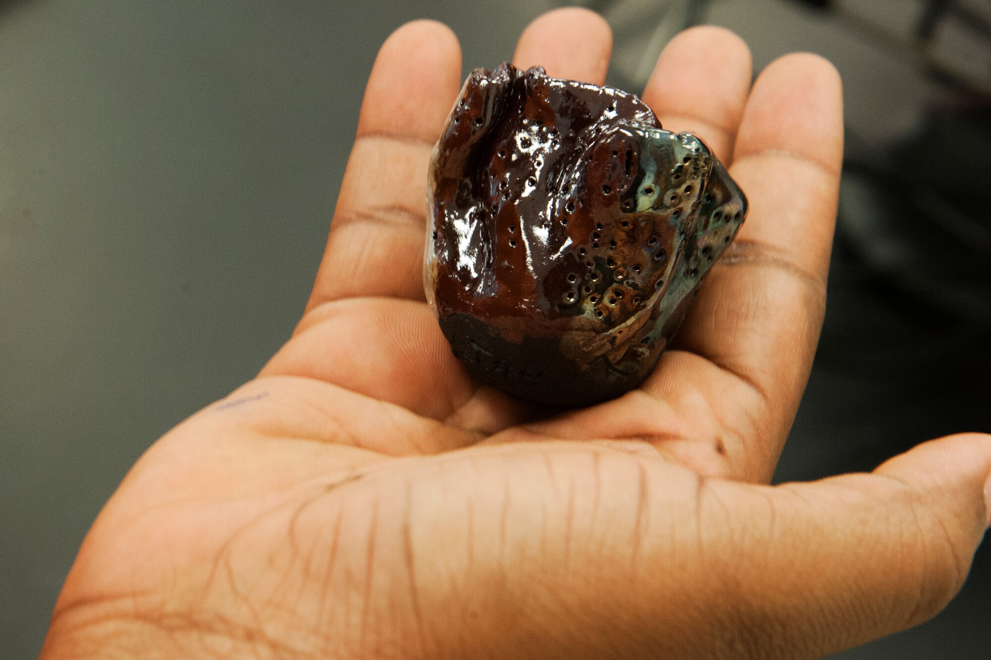 A student holds his finished Raku pottery after polishing it July 18, 2014, during the AMS Materials Camp in Washington, D.C.  The camp brought together middle school educators from the local area to explore new idea in low-budget science experiments to highlight the science, technology, engineering and math fields to classes across the United States. (U.S. Air Force photo/Staff Sgt. Carlin Leslie) 