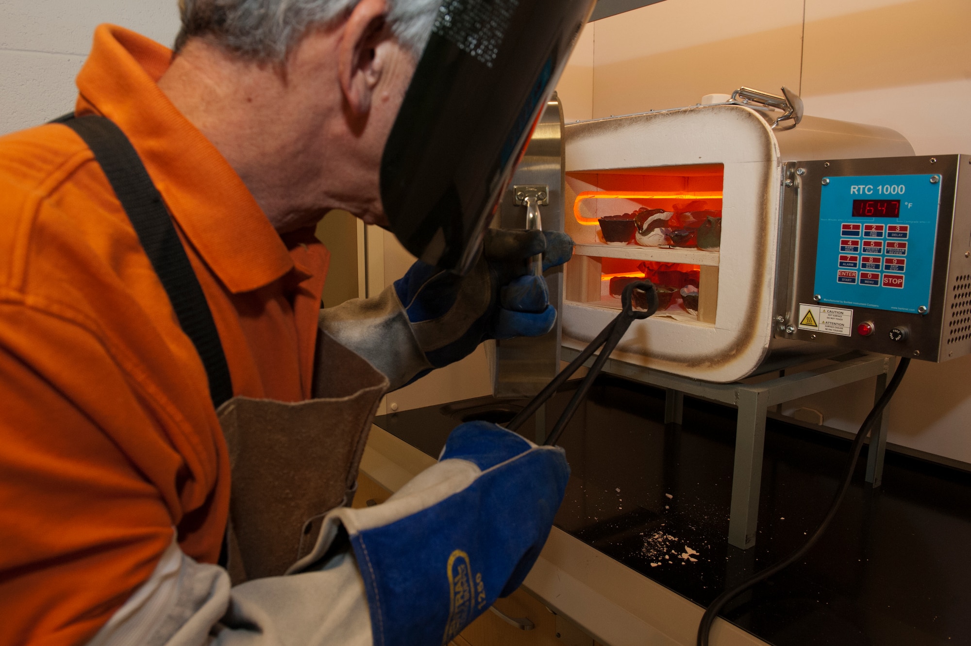 David McGibney opens the kiln to check Raku pottery as part of the ASM Materials Camp July 18, 2014, in Washington, D.C.  Raku is a technique developed in 15th century Japan to make ceramic bowls for the tea ceremony. McGibney is an ASM master teacher. (U.S. Air Force photo/Staff Sgt. Carlin Leslie)