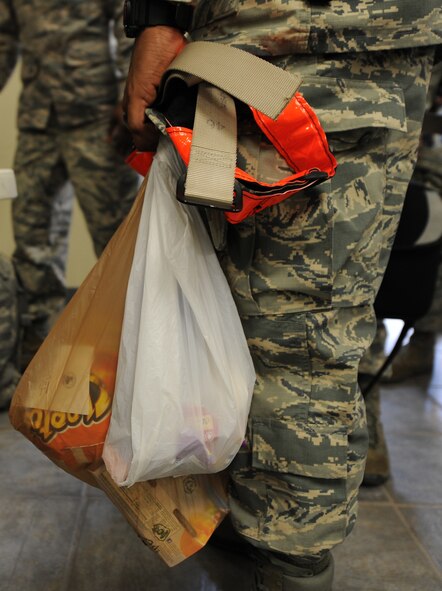 A U.S. Air Force Airman holds a bag of snacks while standing in a deployment processing line, July 29, 2014, at Dyess Air Force Base, Texas. The 9th Bomb Squadron and the 7th Maintenance Group recently deployed to Al Udeid Air Base, Qatar, in support of Operation Enduring Freedom. (U.S. Air Force photo by Airman 1st Class Alexander Guerrero/Released)