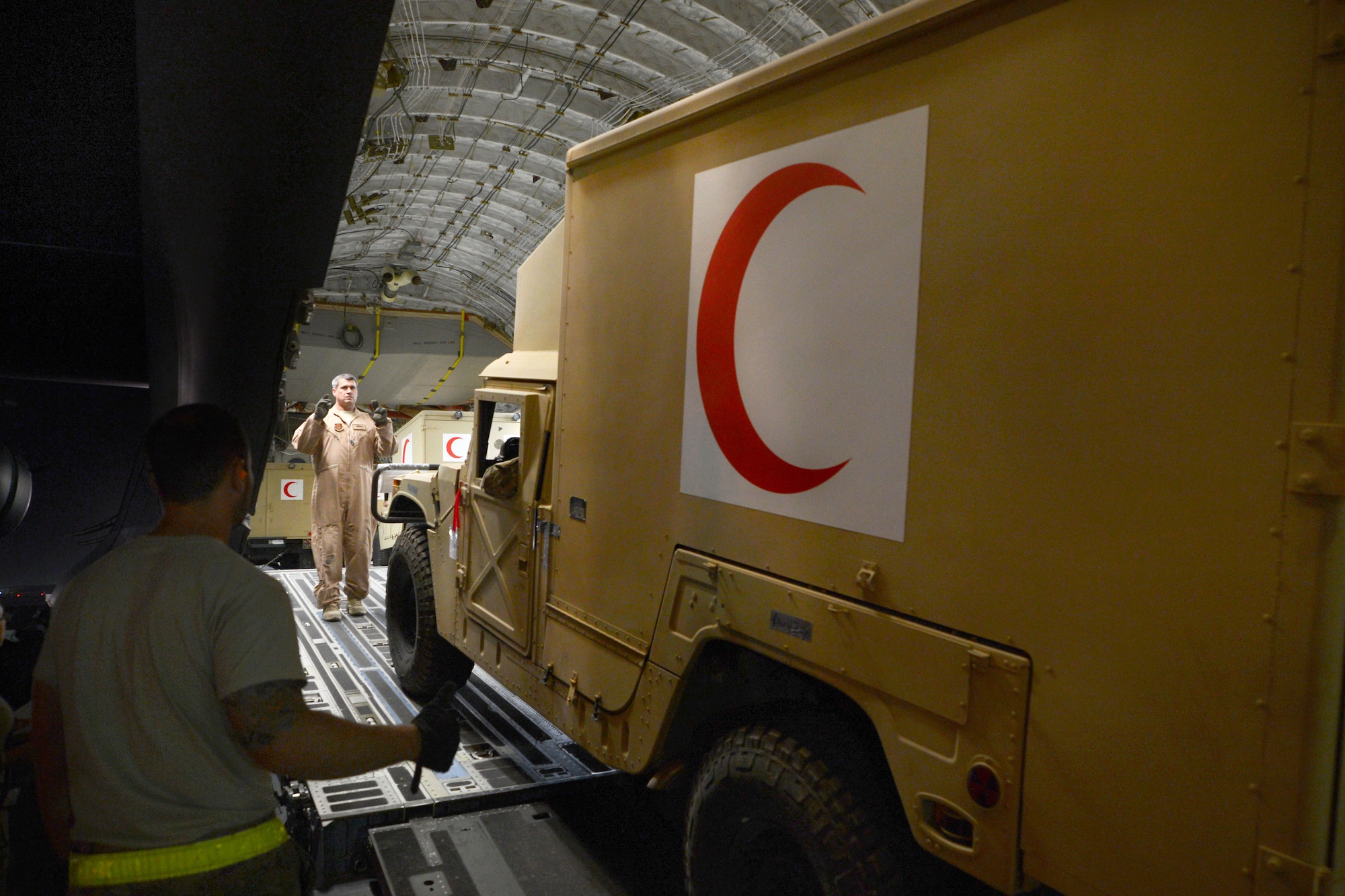 Master Sgt. John Sadorf, right, signals the driver of an Afghan ambulance to cautiously reverse his direction off of a C-17 Globemaster III aircraft on Bagram Airfield, Afghanistan, July 20, 2014. Sadorf, a loadmaster, is assigned to the 817th Airlift Squadron, and deployed from the 313th Airlift Squadron at Joint Base Lewis-McChord, Wash. (U.S. Air Force photo/Master Sgt. Cohen Young)