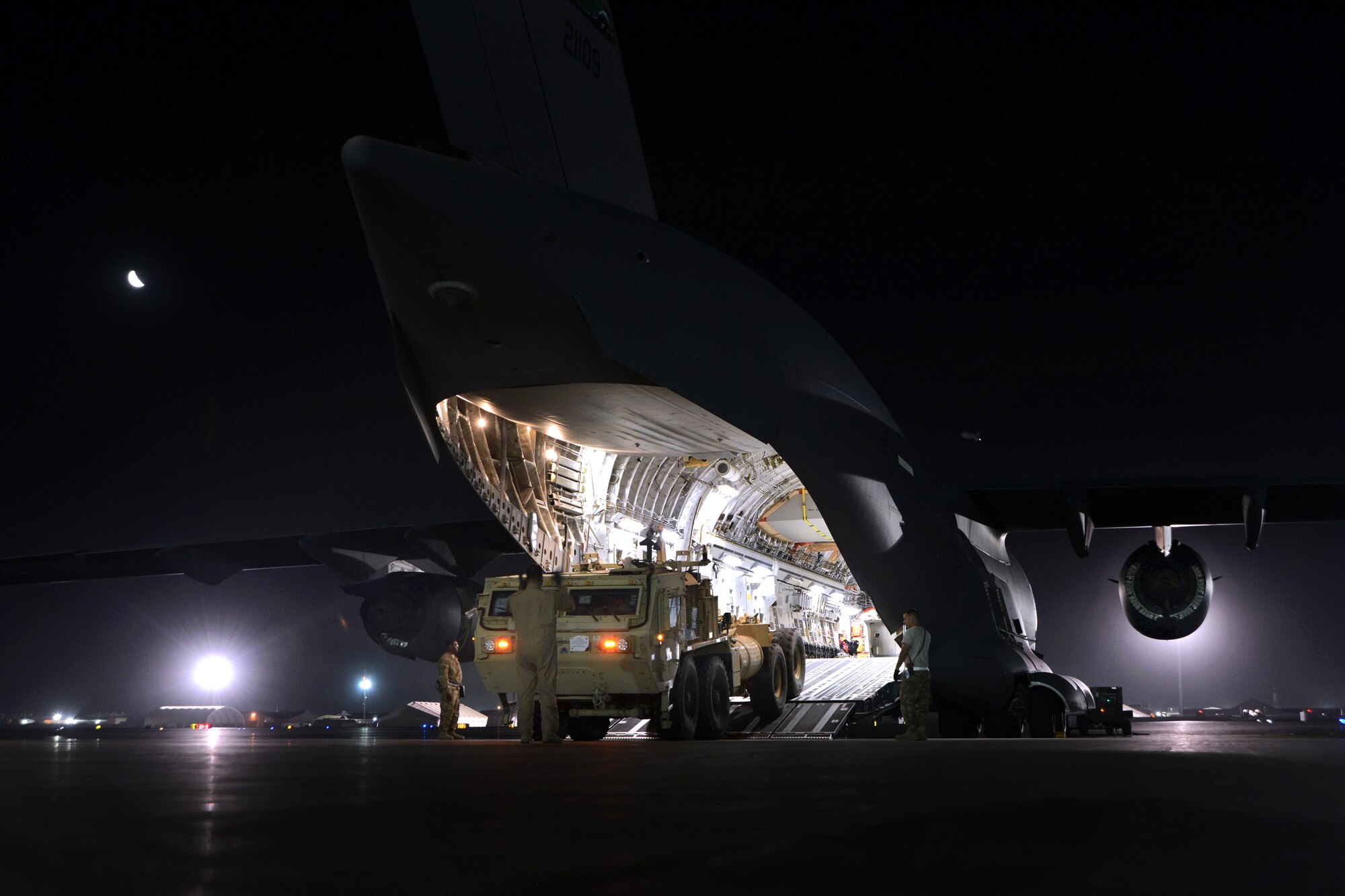 Master Sgt. John Sadorf, foreground, guides the driver of a heavy expanded mobility tactical truck as he backs into a C-17 Globemaster III aircraft during a redeployment mission on Bagram Airfield, Afghanistan, July 20, 2014. Sadorf, a loadmaster, is assigned to the 817th Airlift Squadron, and deployed from the 313th Airlift Squadron at Joint Base Lewis-McChord, Wash. The airmen downloaded six Afghan ambulances before uploading two trucks. (U.S. Air Force photo/Master Sgt. Cohen Young)