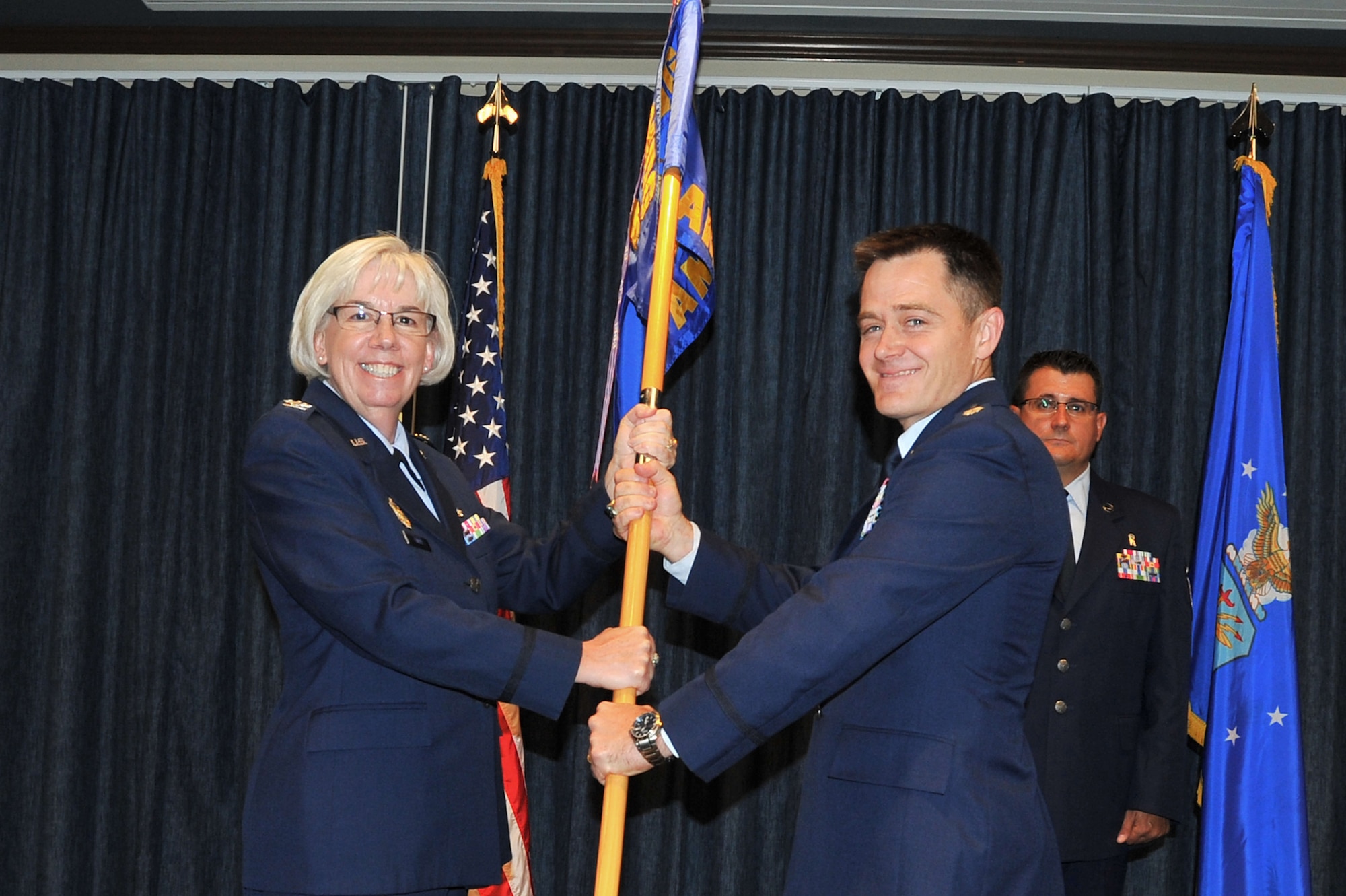Col. Margaret Carey presents the 92nd Aerospace Medicine Squadron guidon to Lt. Colonel Steven Ward during a change of command ceremony at Fairchild Air Force Base, Washington, July 29, 2014. Carey is the 92nd Medical Group commander and Ward is the new 92nd AMDS commander. (U.S. Air Force photo by Staff Sgt. Veronica Montes/Released)