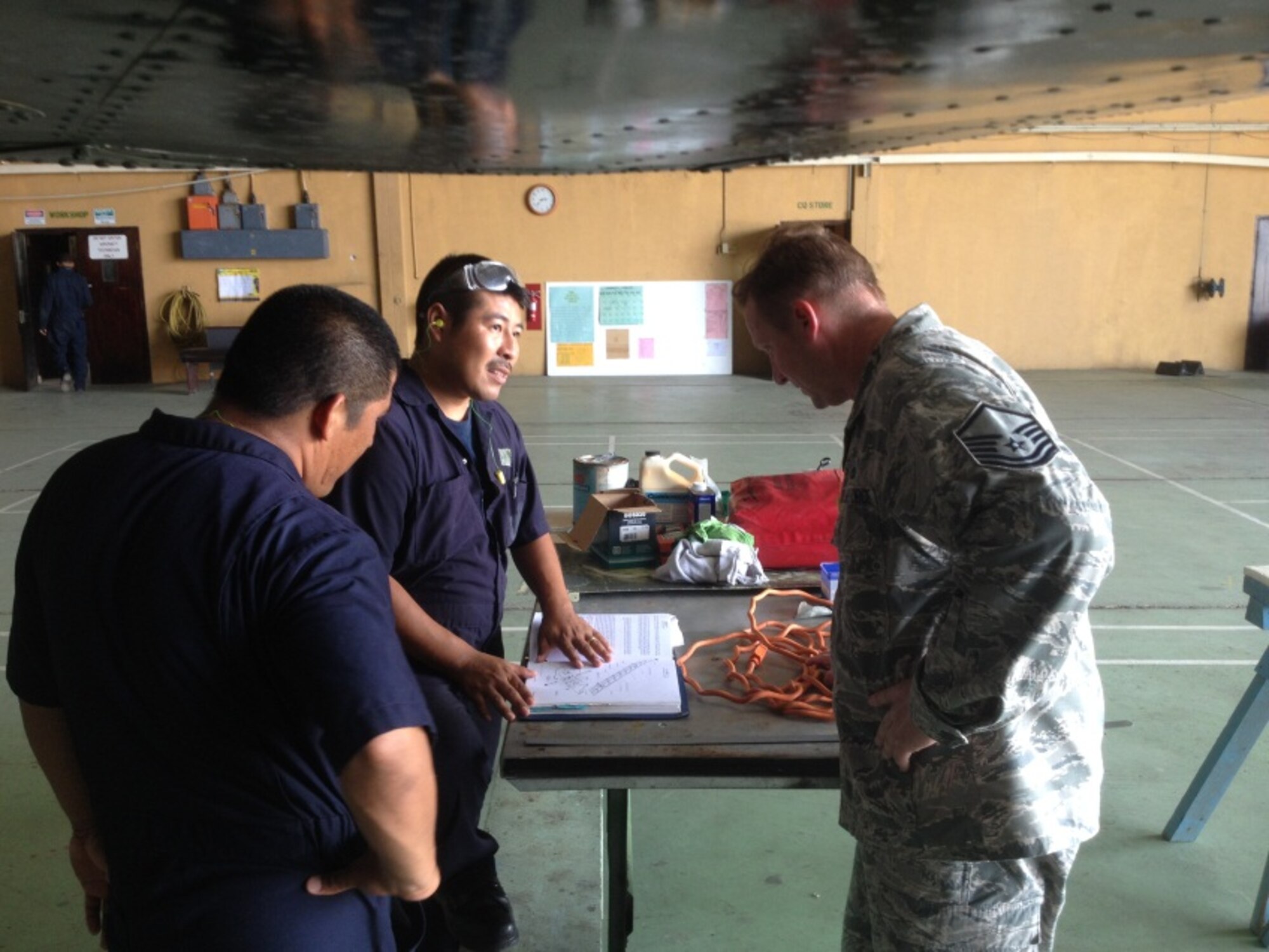 Master Sgt. Jeremy Jacobs, an aircraft manager assigned to 12th Air Force (Air Forces Southern) reviews technical order manuals with members of the Belize Defence Force Air Wing during a mobile training team event in Ladyville, Belize, June 30-July 11. (Courtesy Photo)