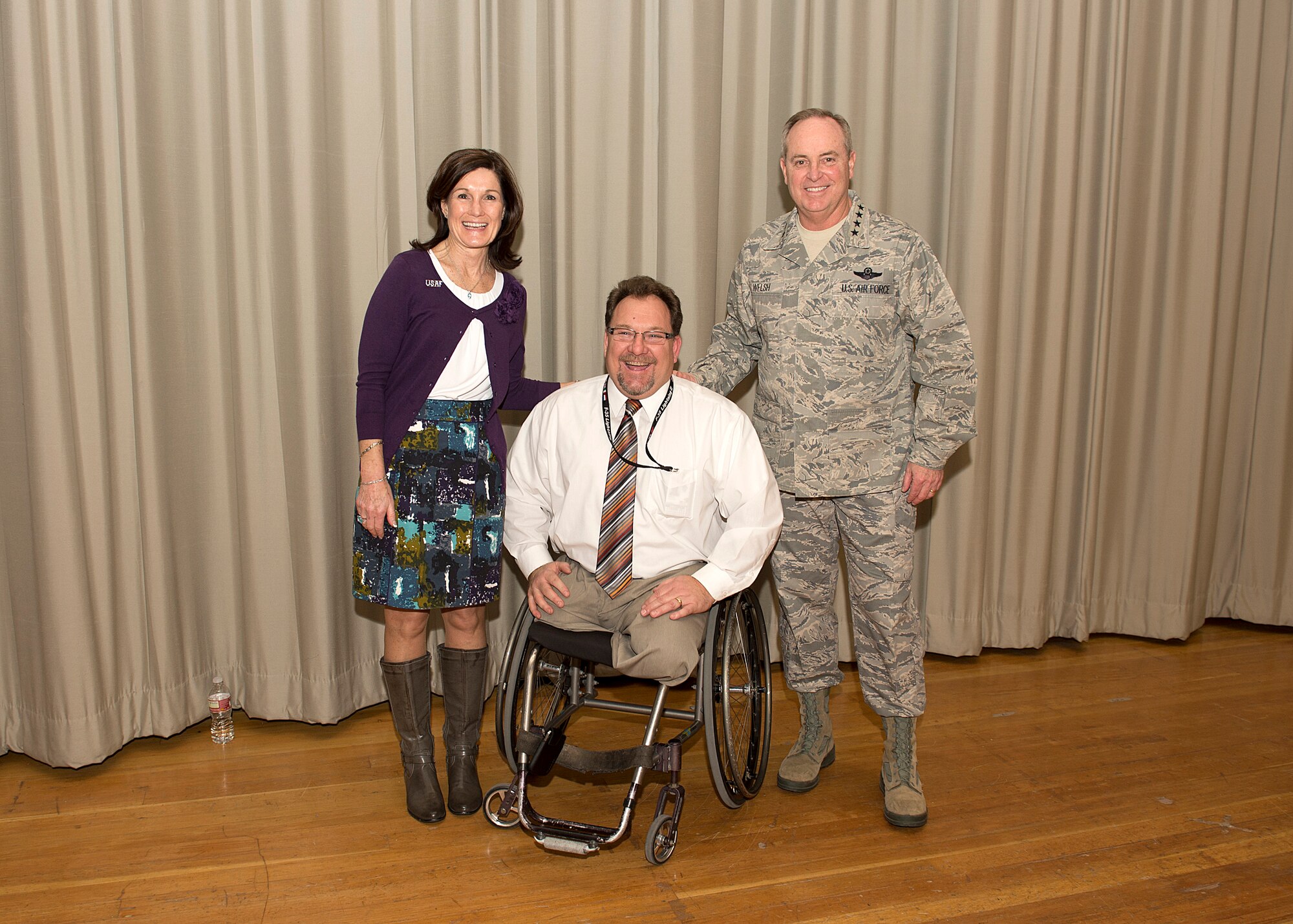 Chief of Staff of the Air Force General Mark A. Welsh III and his wife, Betty, congratulate Dan Osburn, Joint Strike Fighter Combined Test Force, chief engineer, during a commander's call at the Base Theater Jan. 30, 2014. Welsh took the opportunity to recognize Osburn as someone who is dedicated to the mission, leading the JSF test team with a positive “get it done” attitude. (U.S. Air Force photo by Edward Cannon)  