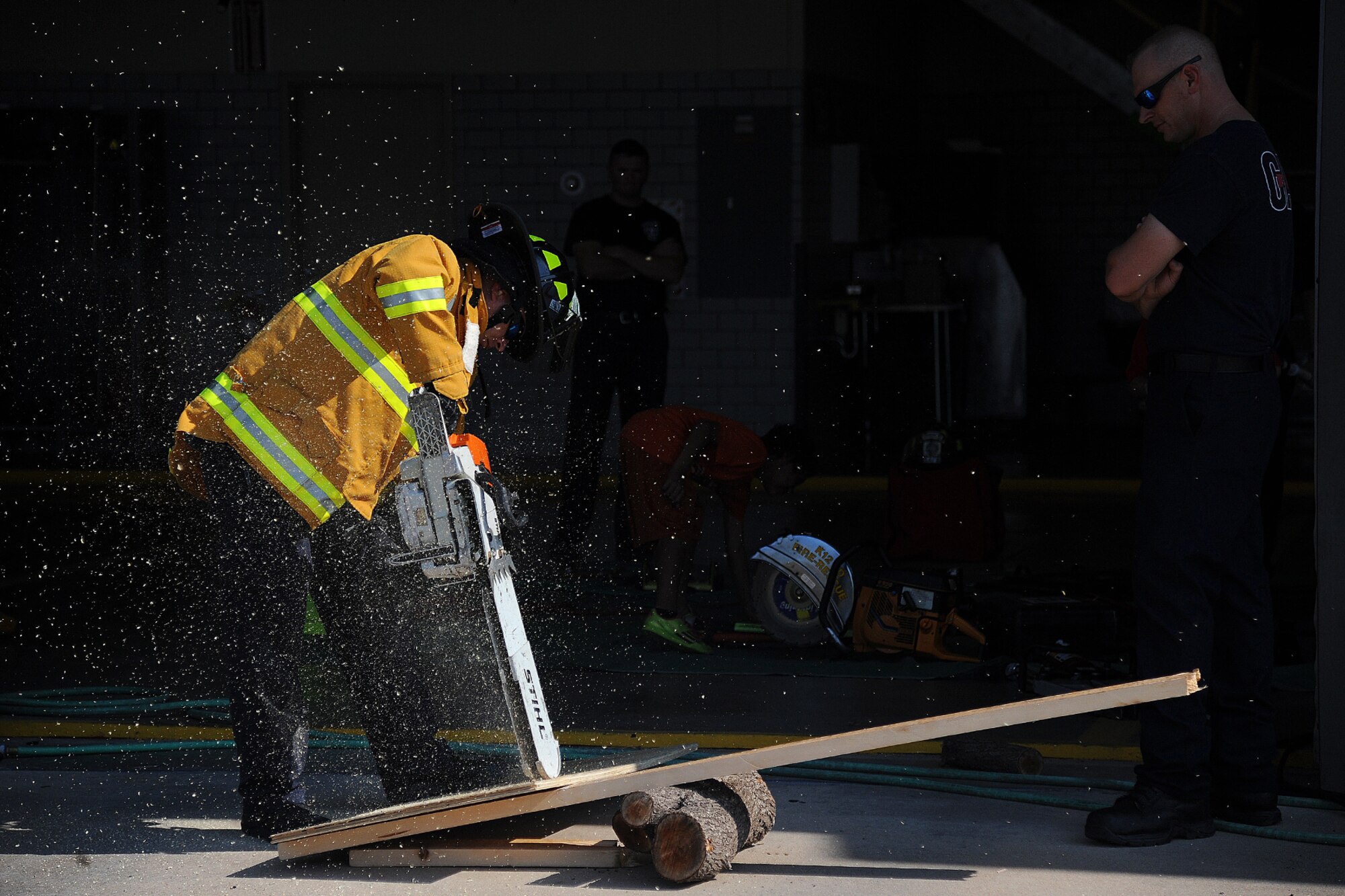 GOODFELLOW AIR FORCE BASE, Texas – Teddy R. Spivey, 17th Civil Engineer Squadron Fire and Emergency Services firefighter, cuts through wood with a chainsaw at the fire department here July 23. Spivey demonstrated how they could use the chainsaw to precisely cut whatever they needed to in order to save someone’s life. (U.S. Air Force photo/ Airman 1st Class Devin Boyer)