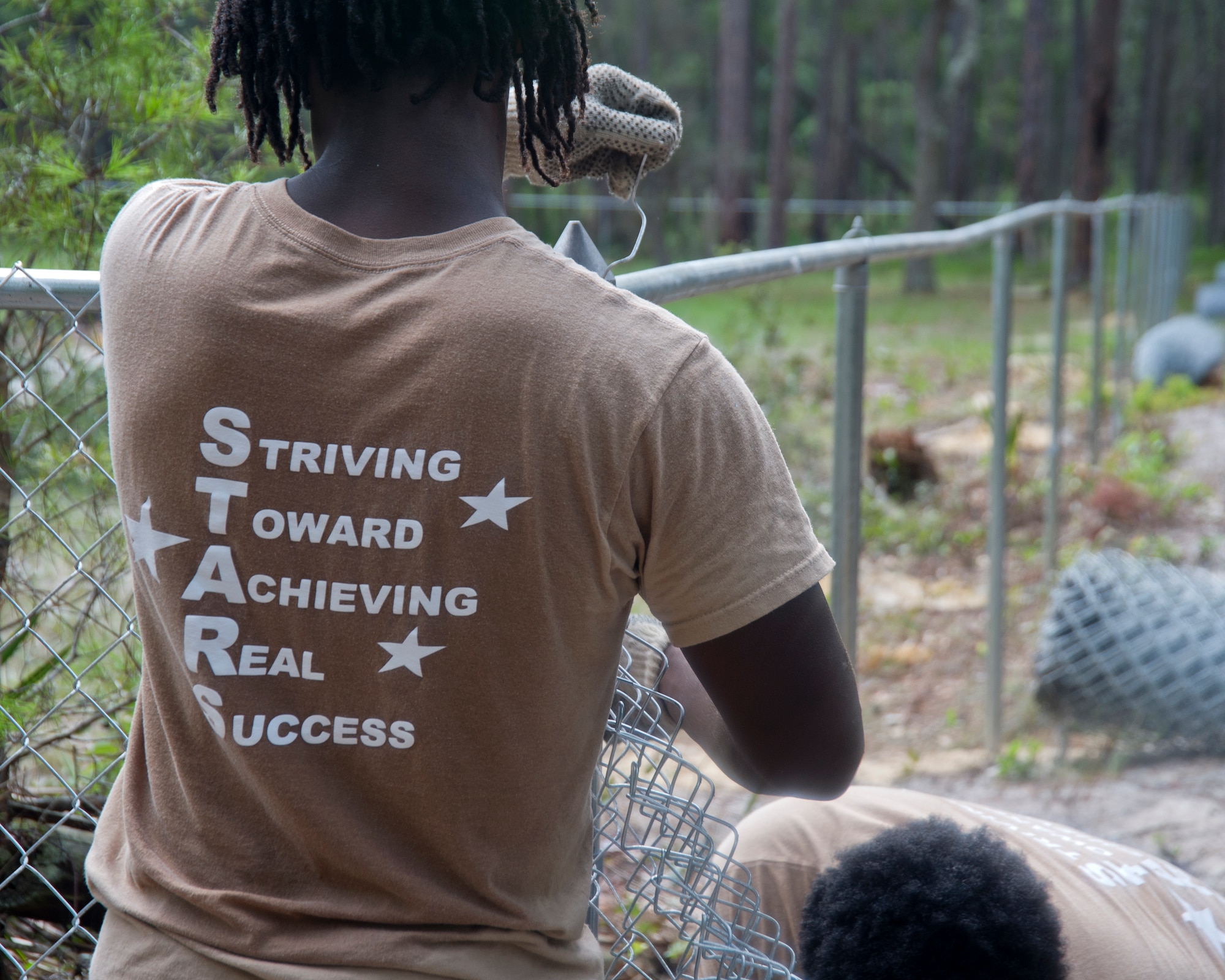 Markeis Goodman, Bay High School student, helps build a fence July 28, at a Tyndall cemetery. He along with three other students from Bay District Schools have constructed around 1,100 feet of fence around Tyndall’s cemeteries to protect and preserve the grave sites on base. (U.S. Air Force photo by Airman 1st Class Alex Echols)