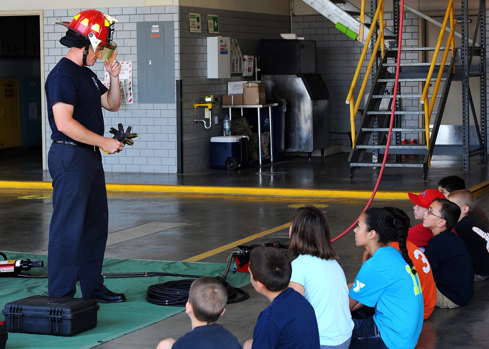 GOODFELLOW AIR FORCE BASE, Texas – Jay T. Teague, 17th Civil Engineer Squadron Fire and Emergency Services firefighter, teaches Junior Fire Fighter Camp participants about safety equipment at the fire department here July 23. Teague explained how the helmet protects firefighters not only from fire, but from falling debris as well. (U.S. Air Force photo/ Airman 1st Class Devin Boyer)