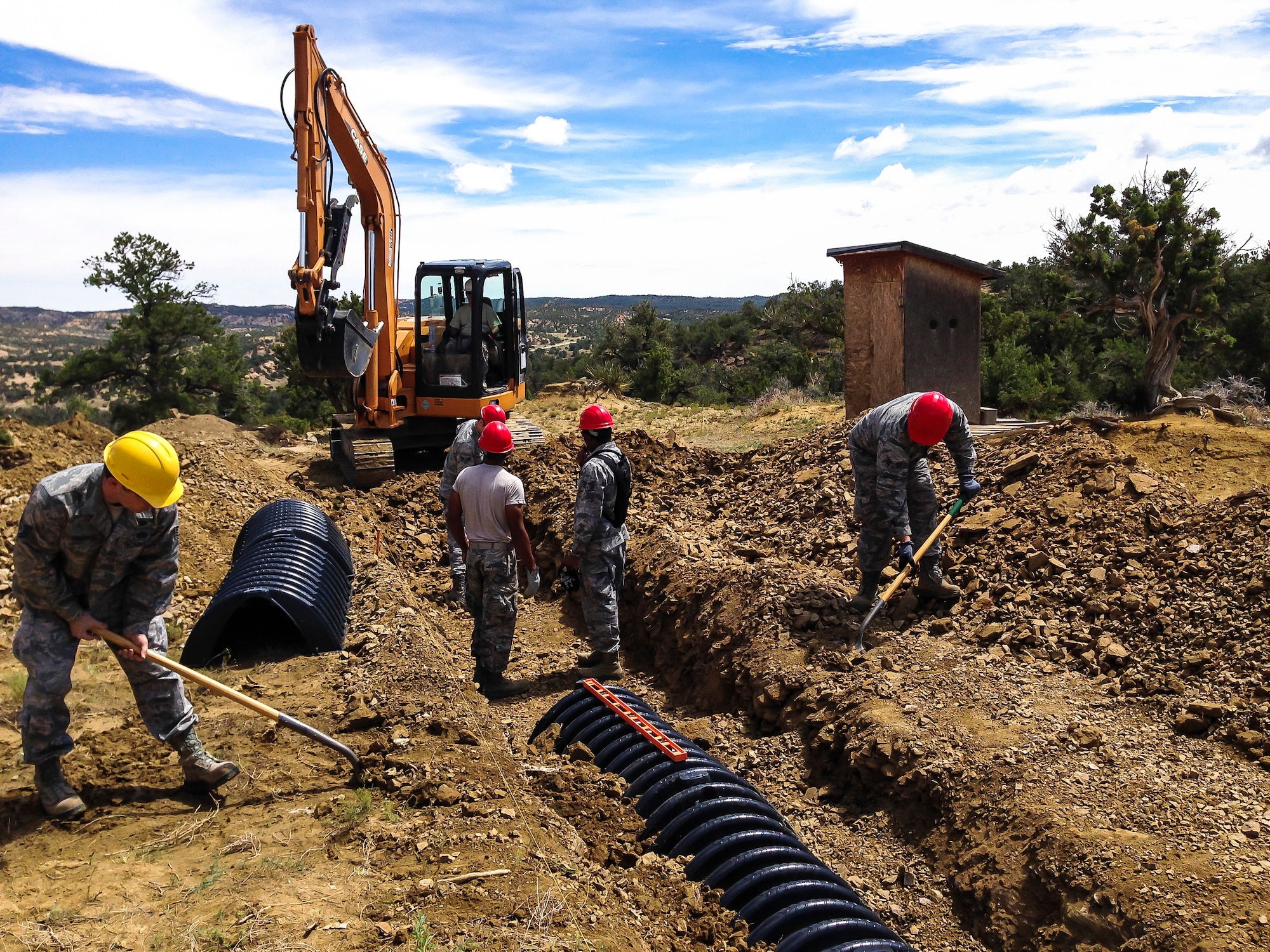 Six members of the 507th Civil Engineer Squadron perform earthwork with shovels and a backhoe at a home site on the Navajo Nation reservation in Gallup, N.M. in July.  The team partnered with a local charity and constructed homes for impoverished Indians as part of Innovative Readiness Training. (U.S. Air Force photo/1st Lt. Christopher Yates)