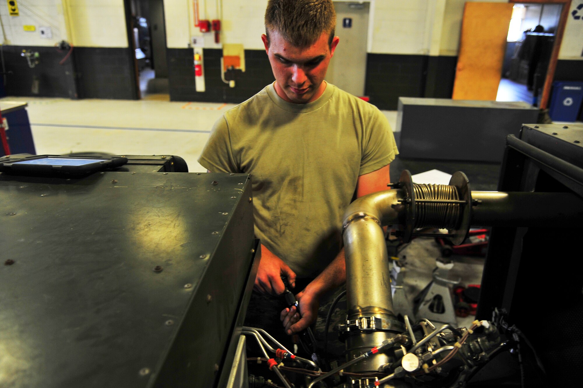 Airman 1st Class Adam Stewart, 5th Maintenance Squadron aerospace ground equipment apprentice, checks safety wiring on a gas turbine engine on Minot Air Force Base, N.D., July 23, 2014. AGE Airmen repair and maintain the ground equipment used to keep B-52H Stratofortresses prepared for flight. (U.S. Air Force photo/Senior Airman Brittany Y. Bateman)