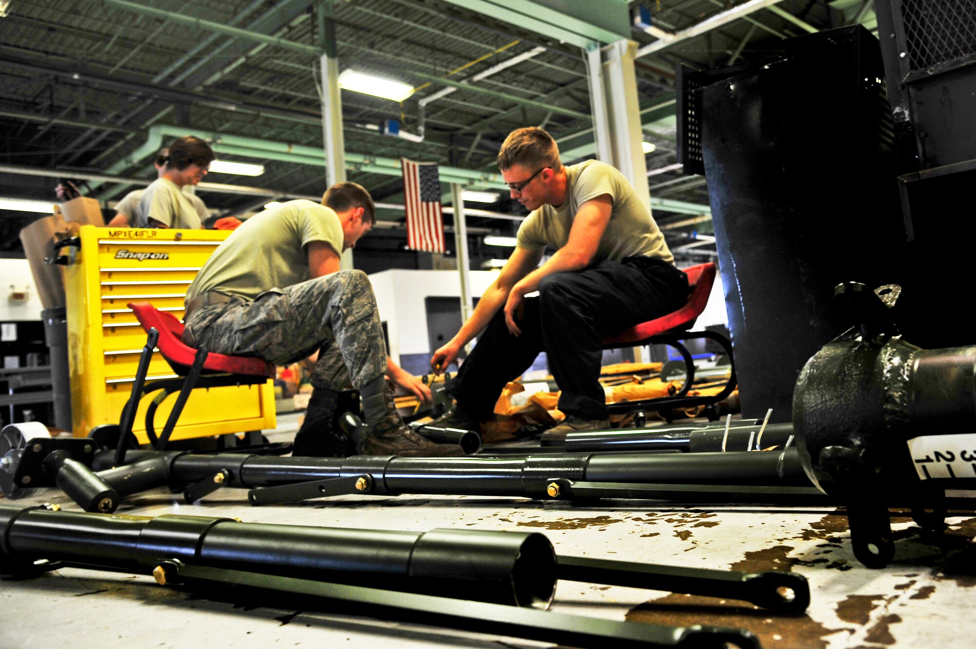 Airman 1st Class Adam Stewart and Airman Matthew Carnes, 5th Maintenance Squadron aerospace ground equipment apprentices, configure an aircraft jack on Minot Air Force Base, N.D., July 23, 2014. AGE Airmen maintain the equipment that supplies electricity, hydraulic pressure and air pressure to planes receiving maintenance on the flight line. (U.S. Air Force photo/Senior Airman Brittany Y. Bateman)