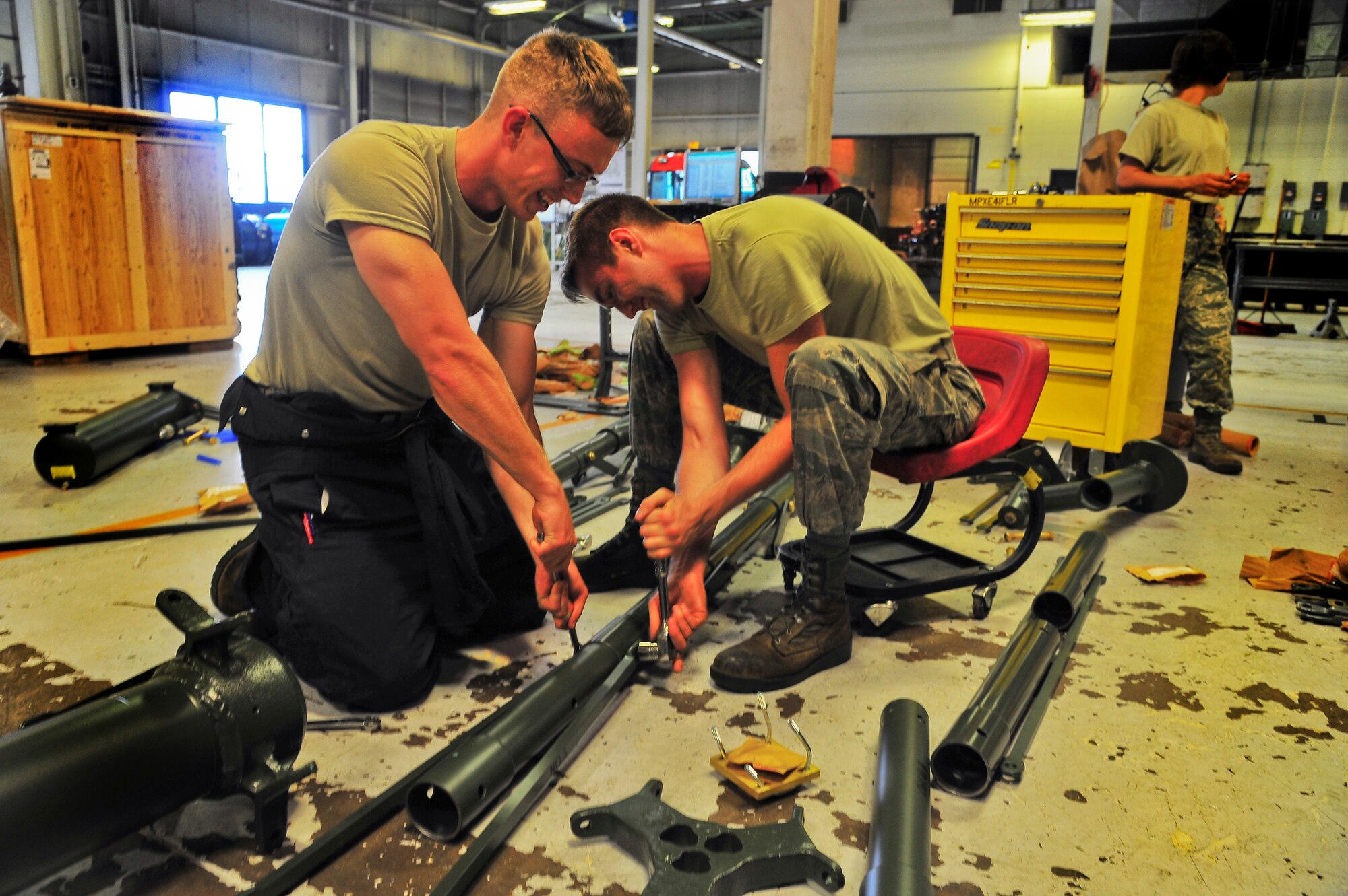 Airman 1st Class Adam Stewart and Airman Matthew Carnes, 5th Maintenance Squadron aerospace ground equipment apprentices, configure an aircraft jack on Minot Air Force Base, N.D., July 23, 2014. AGE Airmen repair and maintain the ground equipment used to keep B-52H Stratofortresses prepared for flight.  (U.S. Air Force photo/Senior Airman Brittany Y. Bateman)