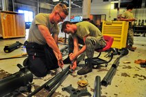 Airman 1st Class Adam Stewart and Airman Matthew Carnes, 5th Maintenance Squadron aerospace ground equipment apprentices, configure an aircraft jack on Minot Air Force Base, N.D., July 23, 2014. AGE Airmen repair and maintain the ground equipment used to keep B-52H Stratofortresses prepared for flight.  (U.S. Air Force photo/Senior Airman Brittany Y. Bateman)