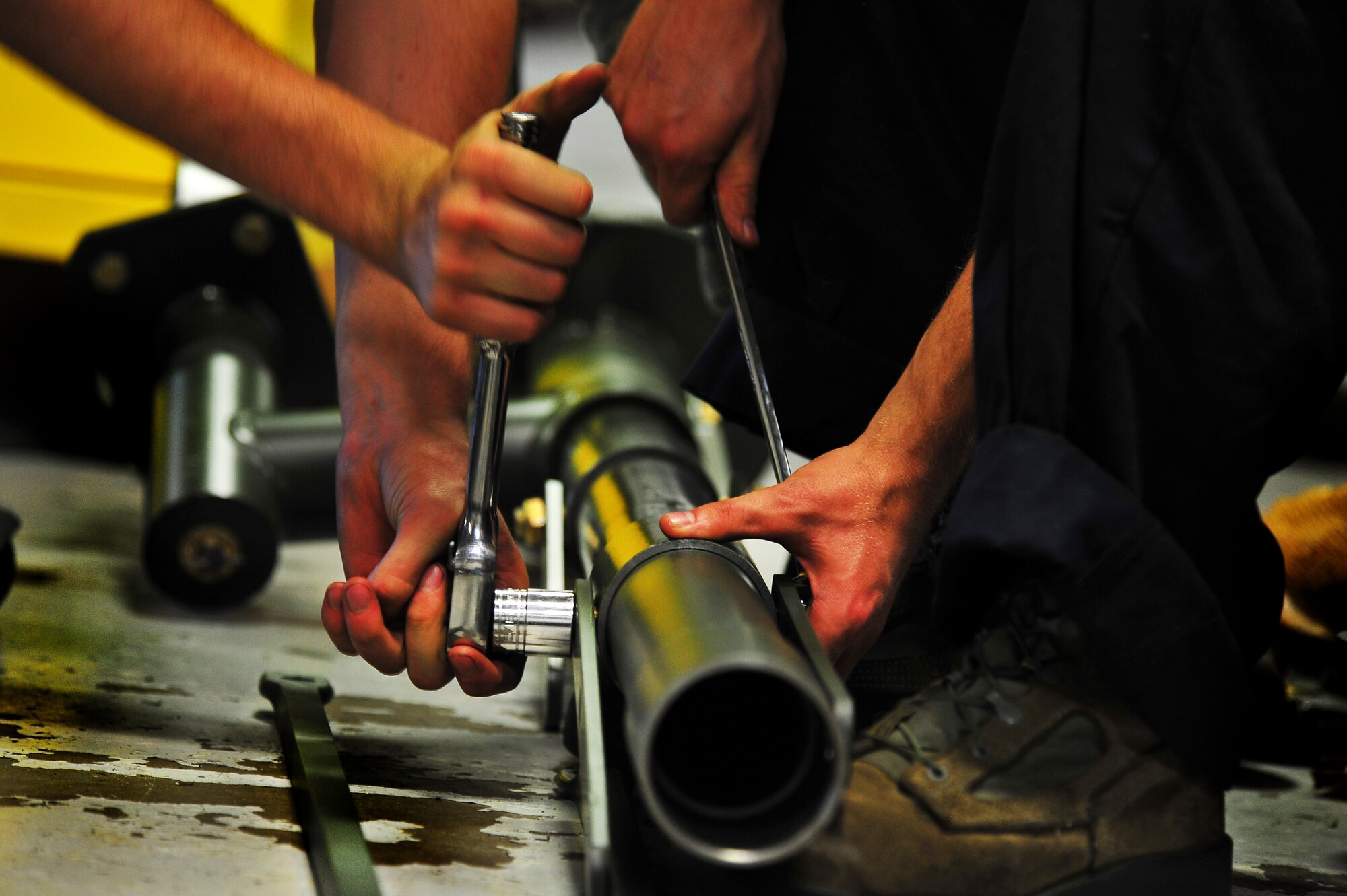 Airman 1st Class Adam Stewart and Airman Matthew Carnes, 5th Maintenance Squadron aerospace ground equipment apprentices, configure an aircraft jack on Minot Air Force Base, N.D., July 23, 2014. AGE Airmen repair and maintain the ground equipment used to keep B-52H Stratofortresses prepared for flight.  (U.S. Air Force photo/Senior Airman Brittany Y. Bateman)