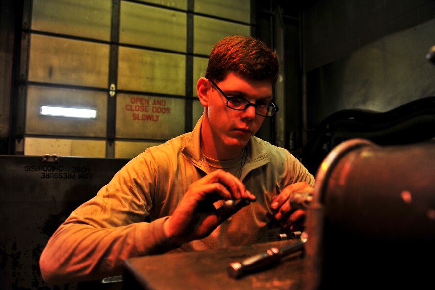 Airman 1st Class Jeffrey Nelson, 5th Maintenance Squadron aerospace ground equipment apprentice, re-panels a self-generating nitrogen cart on Minot Air Force Base, N.D., July 23, 2014.  AGE Airmen maintain the equipment that supplies electricity, hydraulic pressure and air pressure to planes receiving maintenance on the flight line. (U.S. Air Force photo/Senior Airman Brittany Y. Bateman)