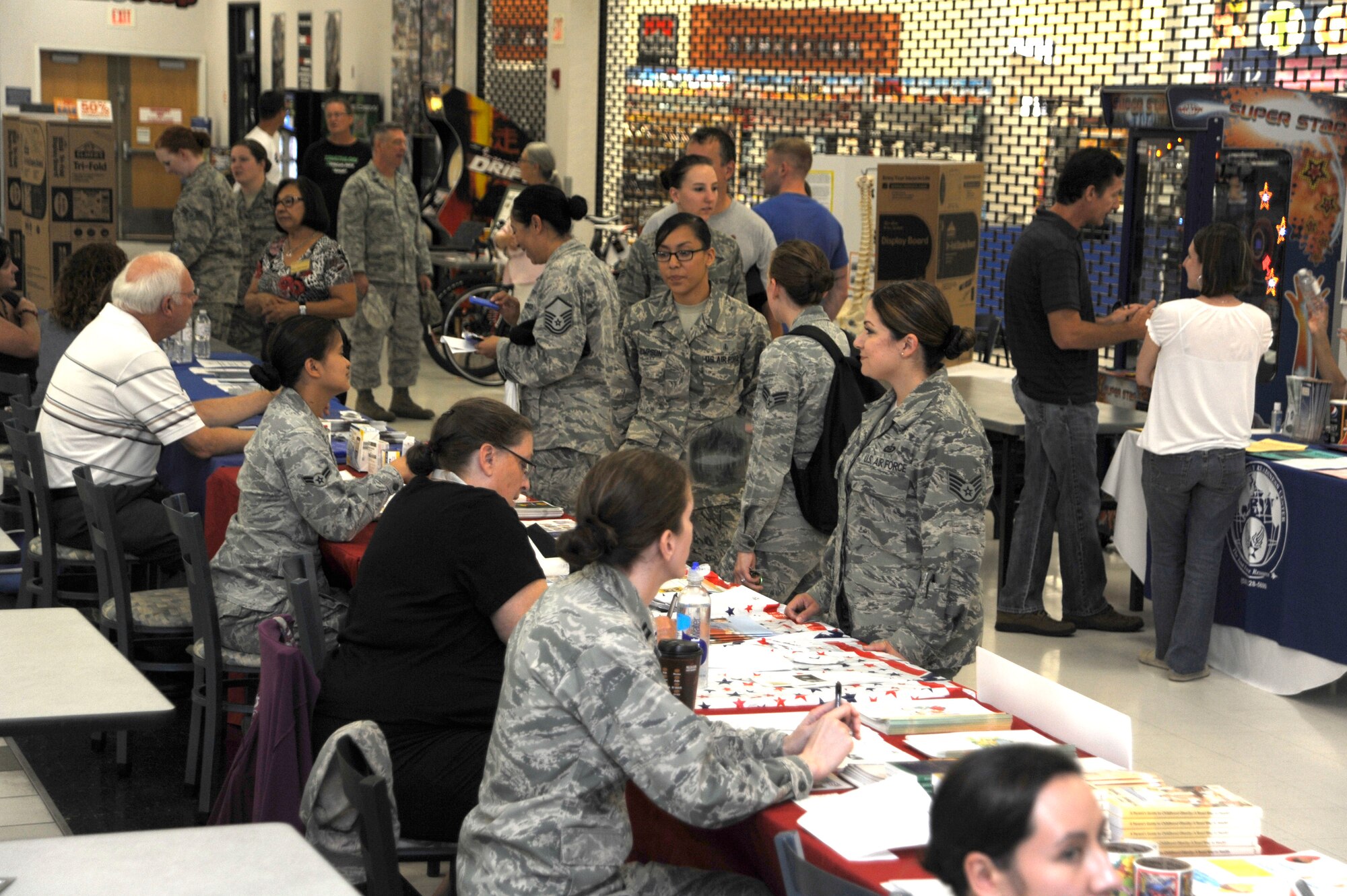 Desert Lightning Team members visit information booths at the Family Health and Fitness Fair at Davis-Monthan Air Force Base, Ariz., July 25, 2014. Eighteen vendors represented programs on the base including Pharmacy, Physical Therapy, Wounded Warrior Program and TriCare. (U.S. Air Force photo by Airman 1st Class Betty R. Chevalier/Released)