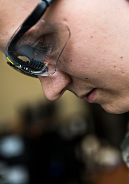Airman 1st Class Anthony Perazzo, 5th Communications Squadron infrastructure technician, uses a wire splitter on computer components in the 5th CS headquarters on Minot Air Force Base, N.D., July 21, 2014. Airmen in the 5th CS infrastructure section maintain, repair and test a variety of mission essential equipment such as computers and area access panels. (U.S. Air Force photo/Senior Airman Stephanie Morris)