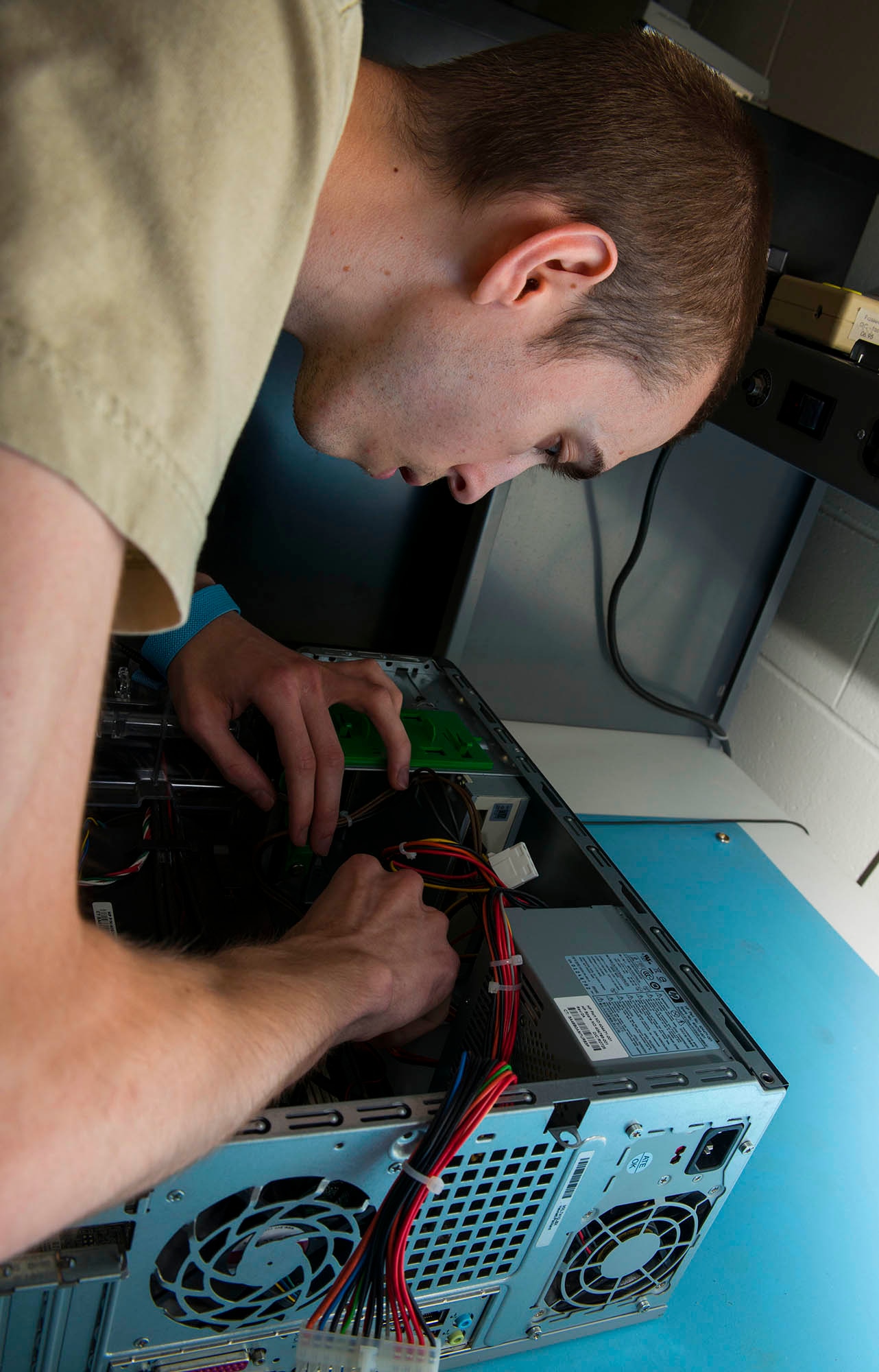 Senior Airman Cody Carlisle, 5th Communications Squadron client support technician, removes a circuit board from a computer in the 5th CS headquarters on Minot Air Force Base, N.D., July 21, 2014. Airmen in the 5th CS maintain and support base communication systems through a variety of equipment including computers, radios and blackberries. (U.S. Air Force photo/Senior Airman Stephanie Morris)