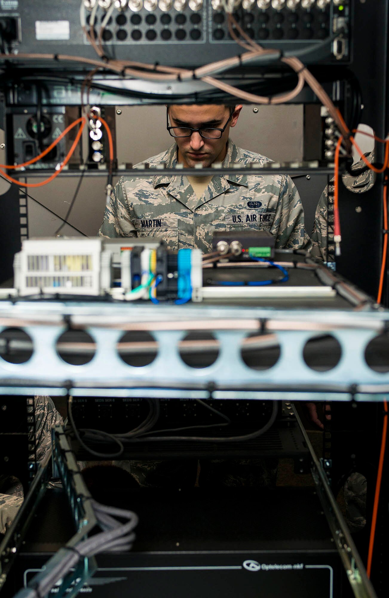 Senior Airman Dennis Martin, 5th Communications Squadron infrastructure technician, troubleshoots a piece of equipment in the 5th CS headquarters on Minot Air Force Base, N.D., July 21, 2014. Airmen in the 5th CS infrastructure section maintain, repair and test a variety of mission essential equipment such as computers and area access panels. (U.S. Air Force photo/Senior Airman Stephanie Morris)