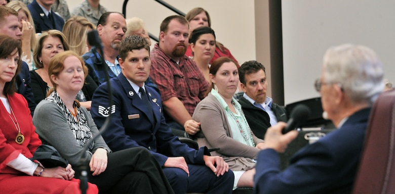 Staff Sgt. Christopher Gilbert (center) and audience members made up of Survival, Evasion, Resistance and Escape graduates and their families along with Fairchild Airmen listen as James J. Bollich talks about his time as a prisoner of war during World War II in the 336th Training Group auditorium at Fairchild Air Force Base, Washington, June 26, 2014. Bollich was a prisoner of war during World War II and a survivor of the Bataan Death March. Gilbert is a paramedic with the 336th TRG (U.S. Air Force photo by Staff Sgt. Alexandre Montes) 
