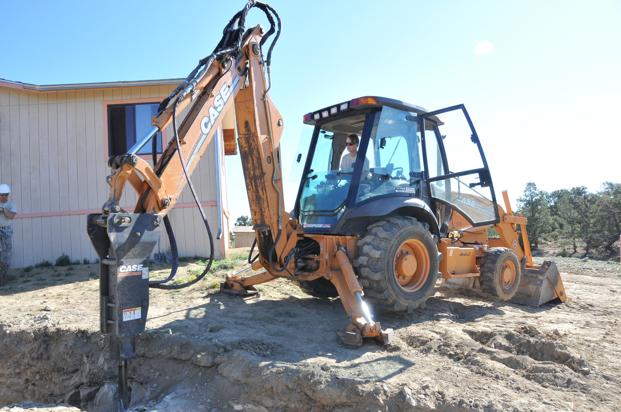 Tech. Sgt. Patricia Kerrigan, 512th Civil Engineer Squadron, drills down on boulders to create a path for the installation of water pipes for a module home previously built in Gallup, N.M. Homes are built for the Navajo reservation as part of a cooperative effort between the Southwest Indian Foundation and the Innovative Readiness Training program created in the Office of the Assistant Secretary of Defense for Reserve Affairs. (U.S. Air Force photo/Staff Sgt. Mercedes Crossland)
