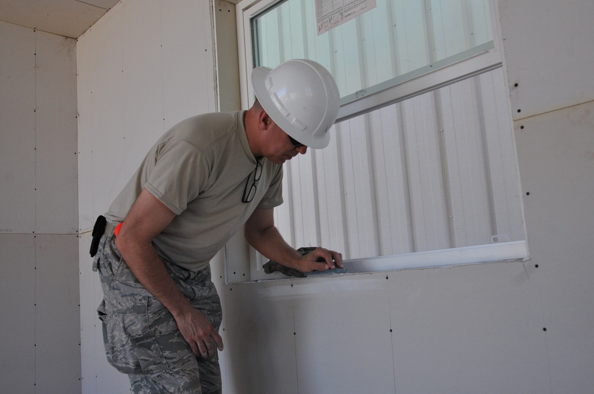 Master Sgt. David Kuntzi, 512th Civil Engineer Squadron, sands down the window sill of a module home being built in Gallup, N.M. Homes are built for the Navajo reservation as part of a cooperative effort between the Southwest Indian Foundation and the Innovative Readiness Training program created in the Office of the Assistant Secretary of Defense for Reserve Affairs. (U.S. Air Force photo/Staff Sgt. Mercedes Crossland)