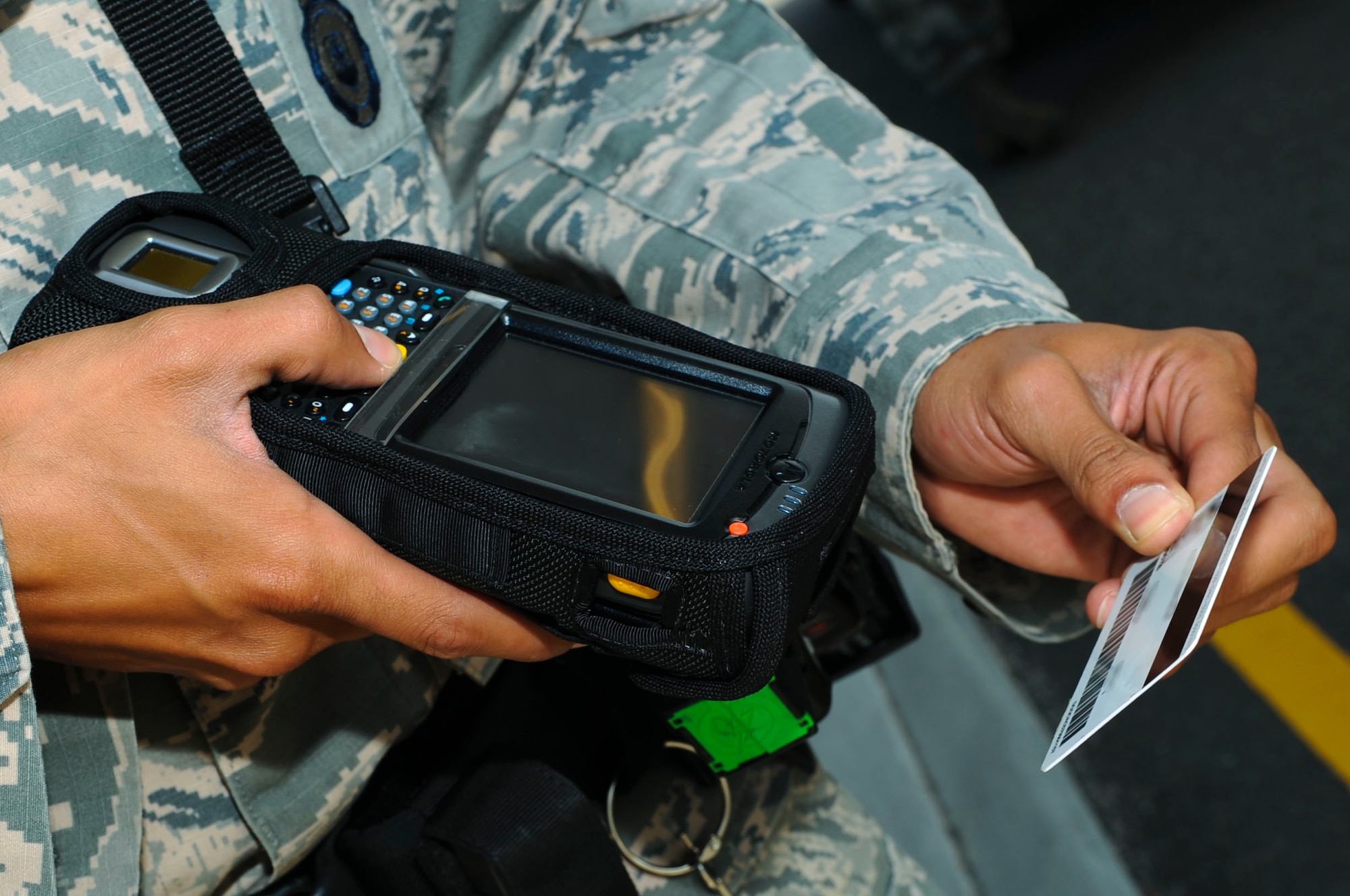 U.S. Air Force Senior Airman Justin Bass, 633rd Security Forces Squadron officer, returns a Common Access Card after scanning it at Langley Air Force Base, Va., July 29, 2014. Due to incompatibility with the Defense Biometric Identification System, retirees with identification cards created before 2003 should visit the Military Personnel Section prior to Jan. 1, 2015, to attain an up-to-date ID card; and contractors with locally-generated badges must visit the VCC for their new IDs. (U.S. Air Force photo by Senior Airman Austin Harvill/Released)