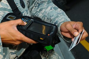 U.S. Air Force Senior Airman Justin Bass, 633rd Security Forces Squadron officer, returns a Common Access Card after scanning it at Langley Air Force Base, Va., July 29, 2014. Due to incompatibility with the Defense Biometric Identification System, retirees with identification cards created before 2003 should visit the Military Personnel Section prior to Jan. 1, 2015, to attain an up-to-date ID card; and contractors with locally-generated badges must visit the VCC for their new IDs. (U.S. Air Force photo by Senior Airman Austin Harvill/Released)