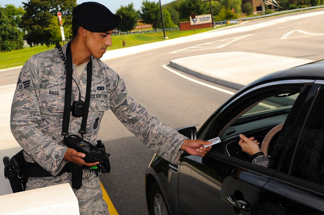 U.S. Air Force Senior Airman Justin Bass, 633rd Security Forces Squadron officer, returns a Common Access Card after scanning it at Langley Air Force Base, Va., July 29, 2014. Due to incompatibility with the Defense Biometric Identification System, retirees with identification cards created before 2003 should visit the Military Personnel Section prior to Jan. 1, 2015, to attain an up-to-date ID card; and contractors with locally-generated badges must visit the VCC for their new IDs. (U.S. Air Force photo by Senior Airman Austin Harvill/Released)