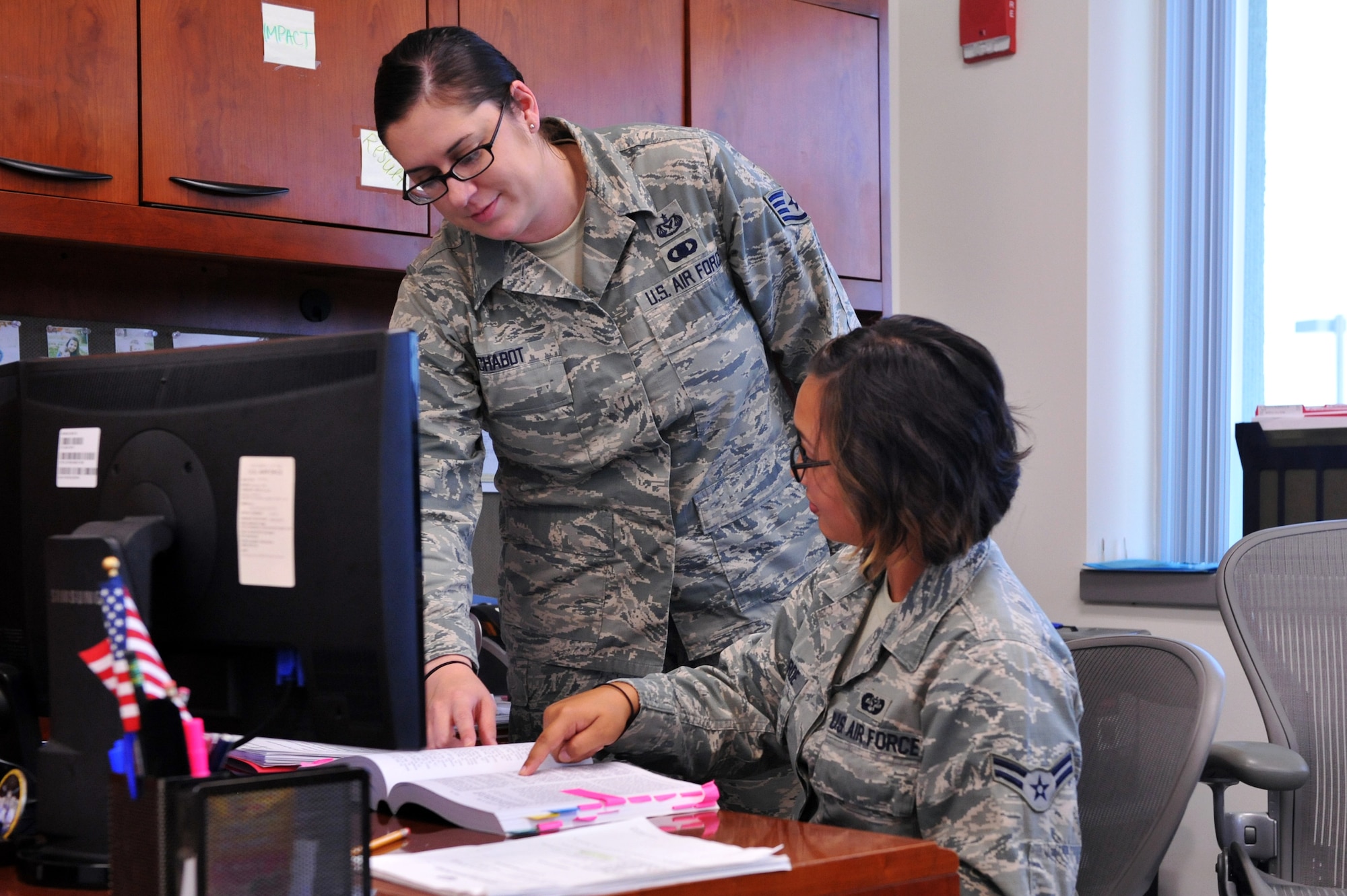 Airman 1st Class Amanda L. Belarde, 460th Space Wing Legal Office military justice paralegal, right, and Staff Sgt. Michelle Chabot, 460th Space wing Legal Office NCOIC of military justice, look over reference material July 29, 2014, in the 460th Space Wing Legal Office on Buckley Air Force Base, Colo. Paralegals support virtually every area of the legal office, including military justice, claims, civil law, legal assistance, contracts and environmental law.