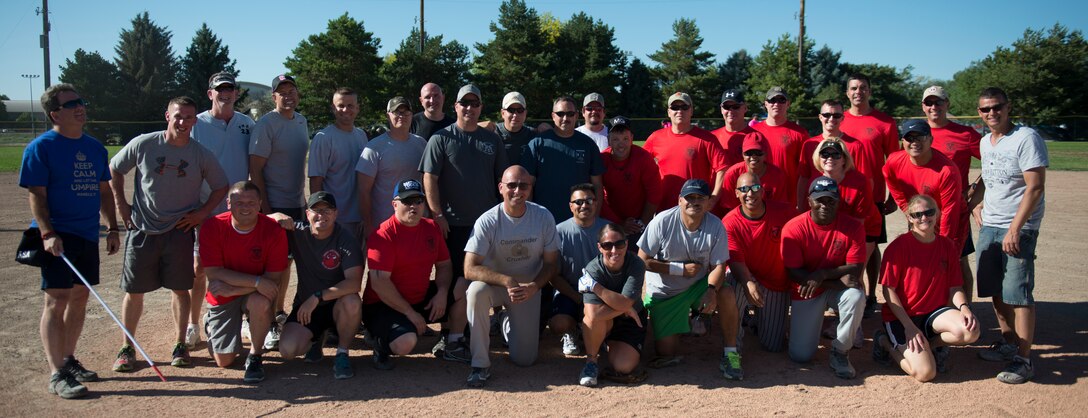 Teams pose together after the commanders versus chiefs and first sergeants opening game of the Operation Warmheart softball tournament, July 25, 2014, at Mountain Home Air Force Base, Idaho. The chiefs and first sergeants emerged victorious. (U.S. Air Force photo by Airman 1st Class Malissa Lott/RELEASED)