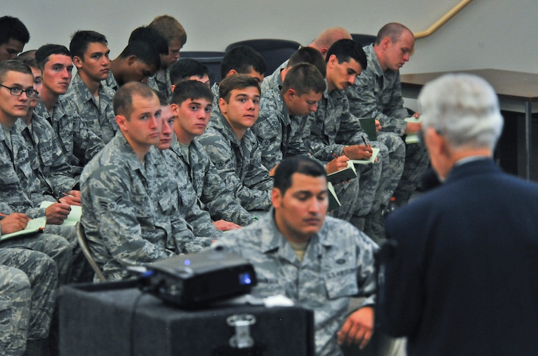 Students of the 22nd Training Squadron takes notes as they listen to James J. Bollich as he talks about evading the enemy at Fairchild Air Force Base, Washington, June 26, 2014. Bollich was a prisoner of war during World War II and a survivor of the Bataan Death March. Members of Fairchild listened to Bollich speak about how Survival, Evasion, Resistance and Escape training saved his life and the importance of their training. (U.S. Air Force photo by Staff Sgt. Alexandre Montes/Released)